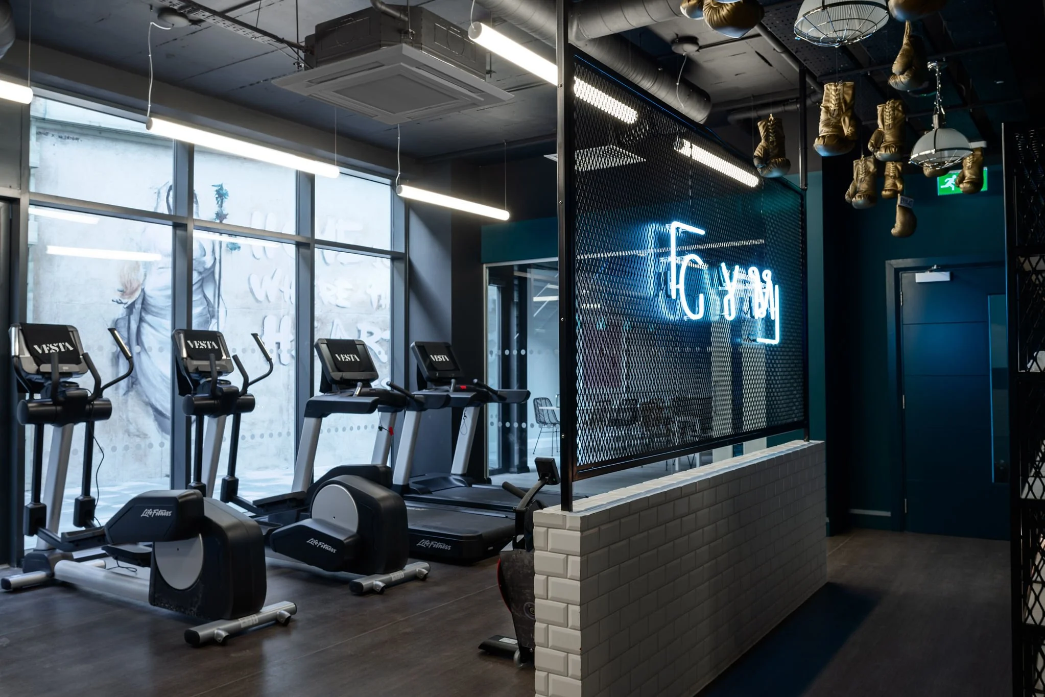 treadmills in gym with neon gym sign