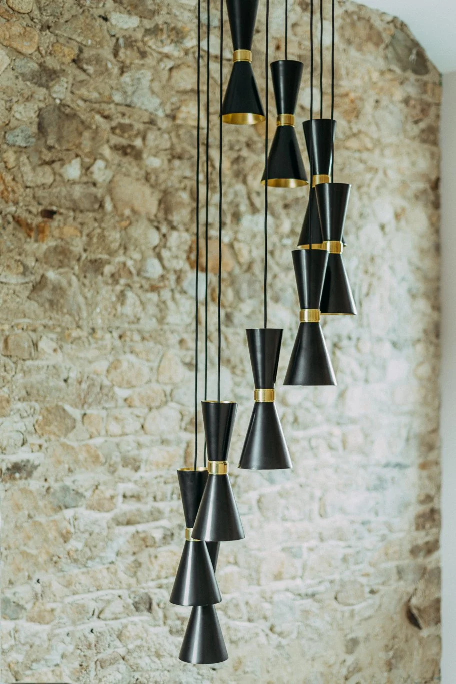 tall lighting pendant against stone wall backdrop