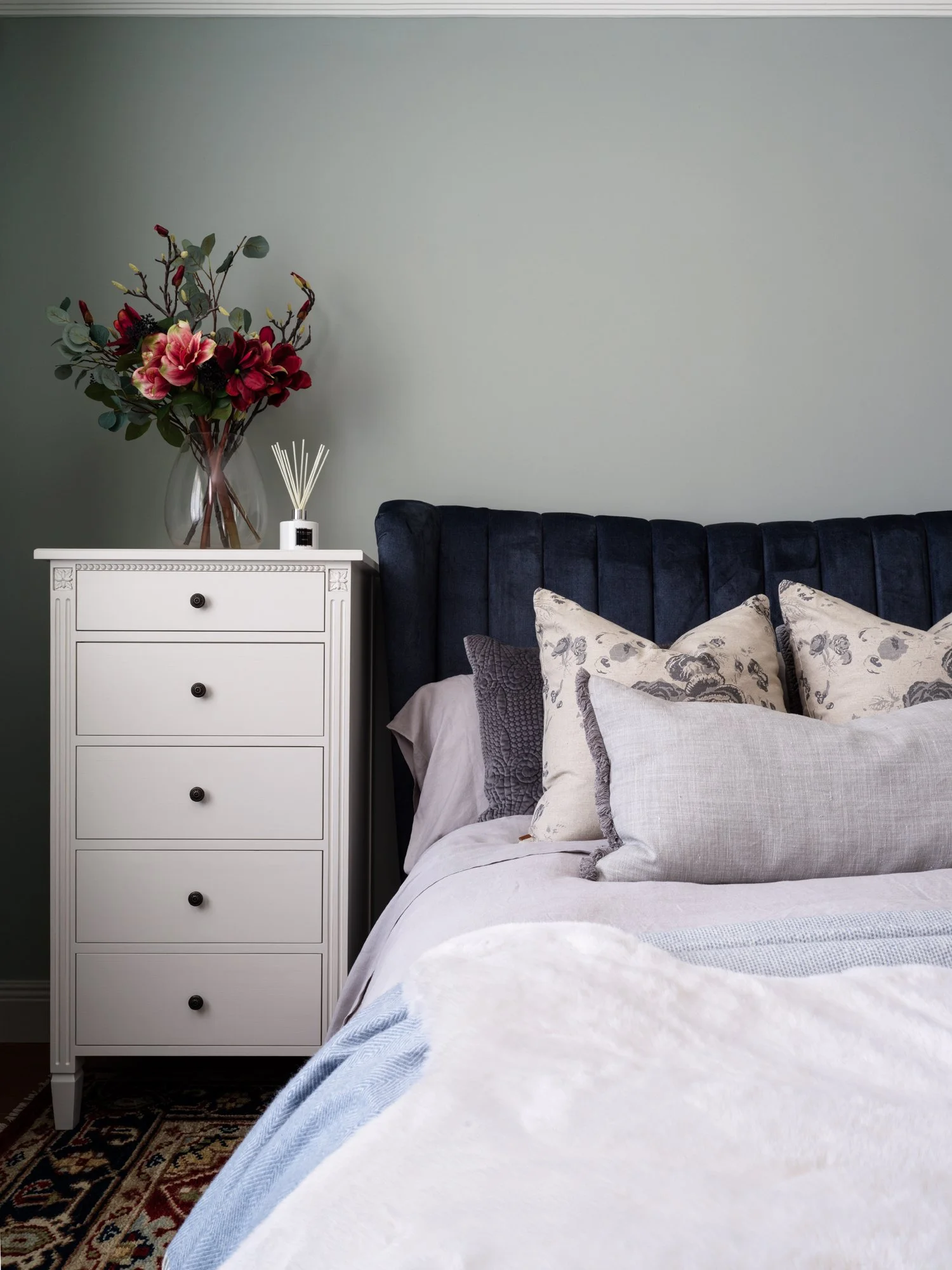 cream bedside drawers and navy headboard
