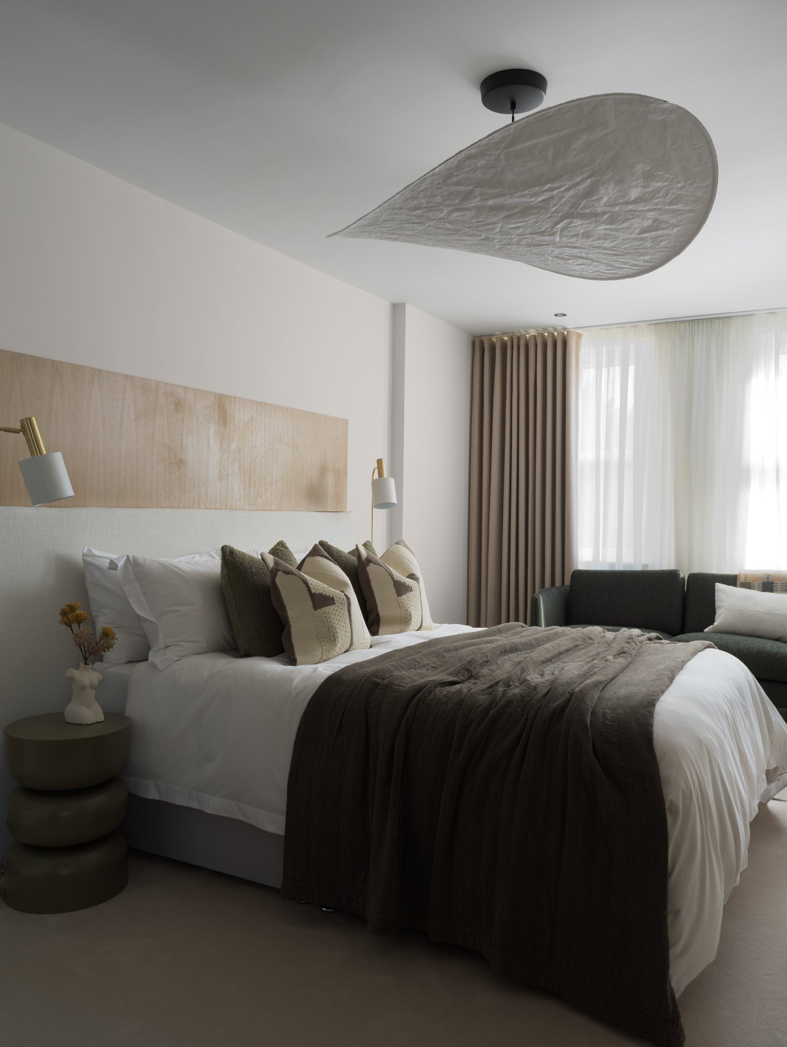 master bedroom with large lampshade and brown throw