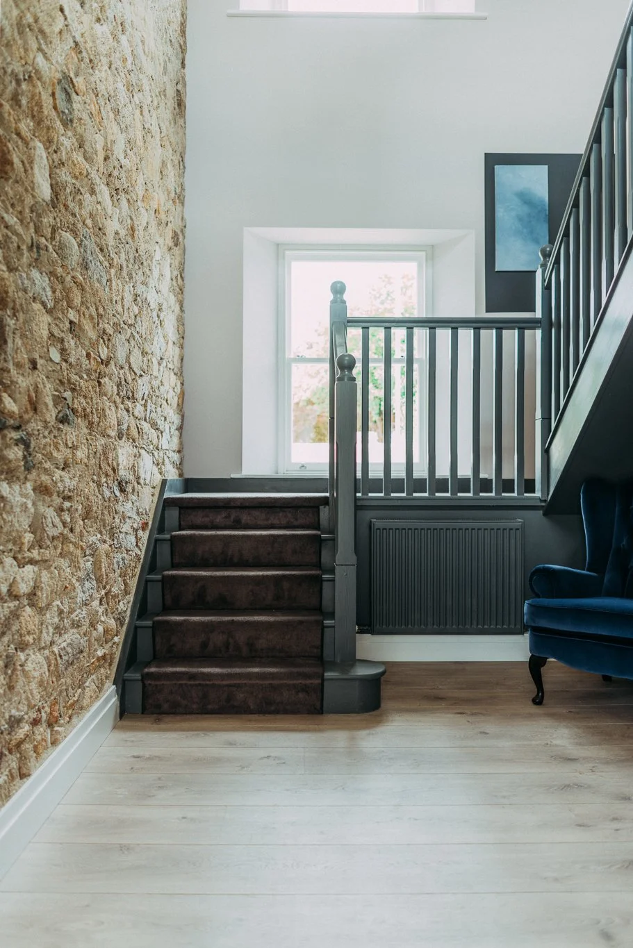 stone wall hallway with green staircase
