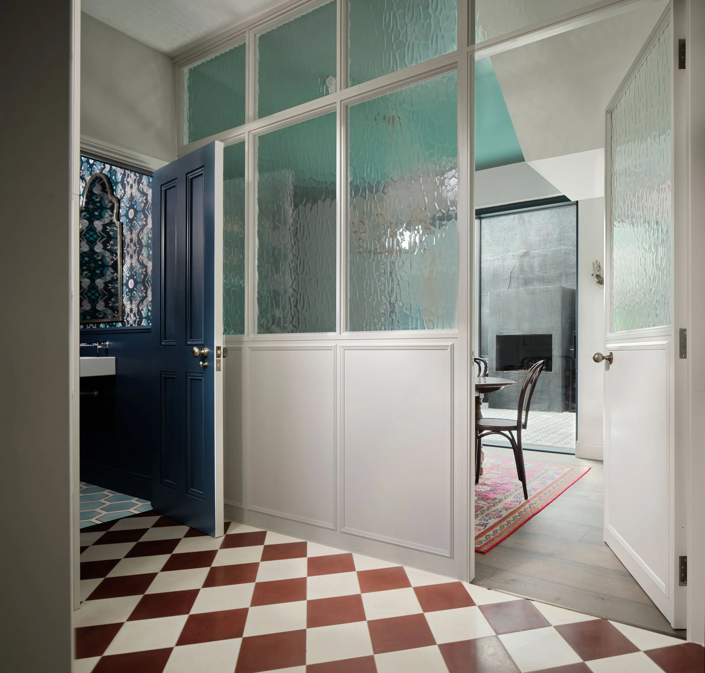 checkered hallway floor with glazed panelling between living room