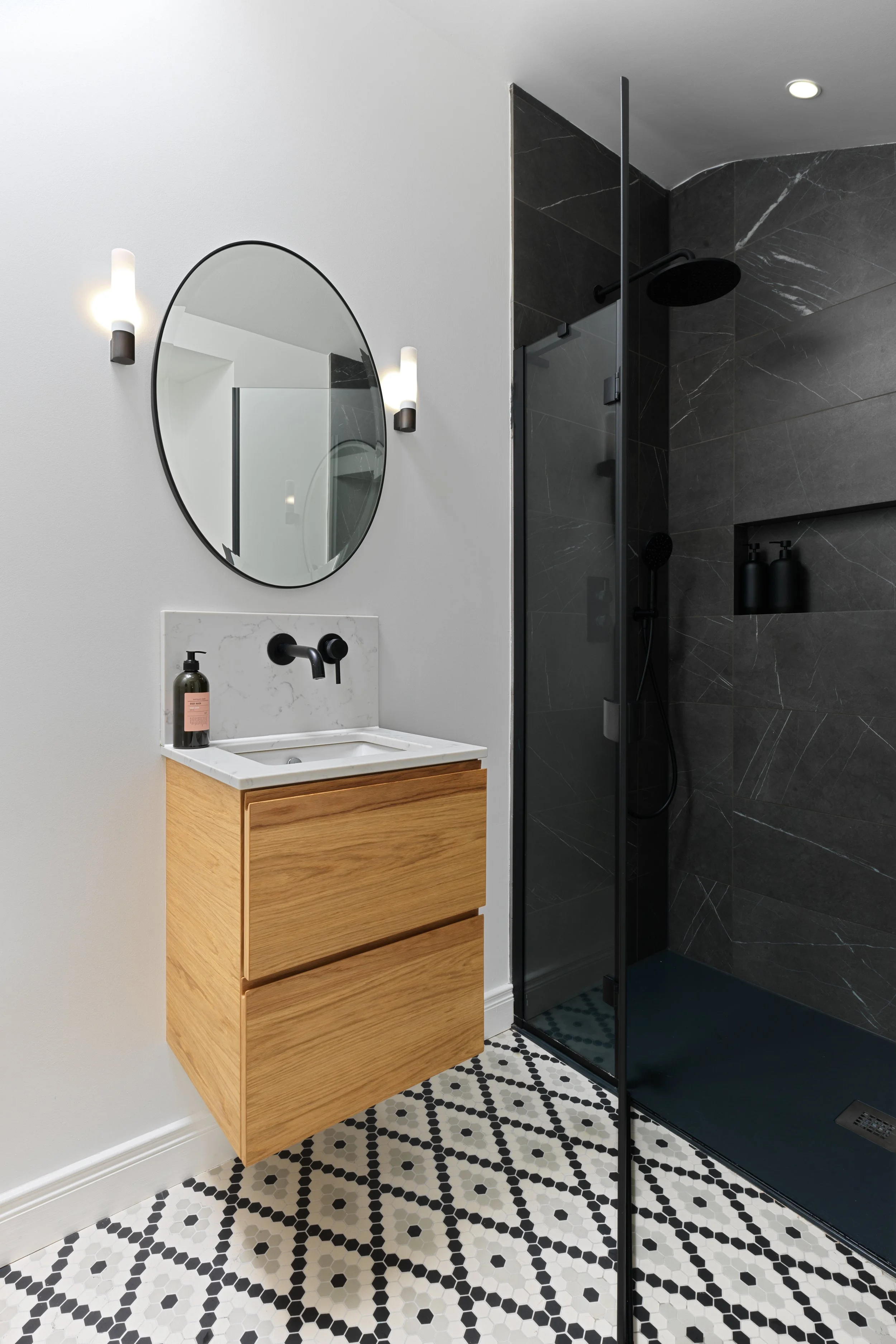 black shower with patterned floor of en-suite bathroom