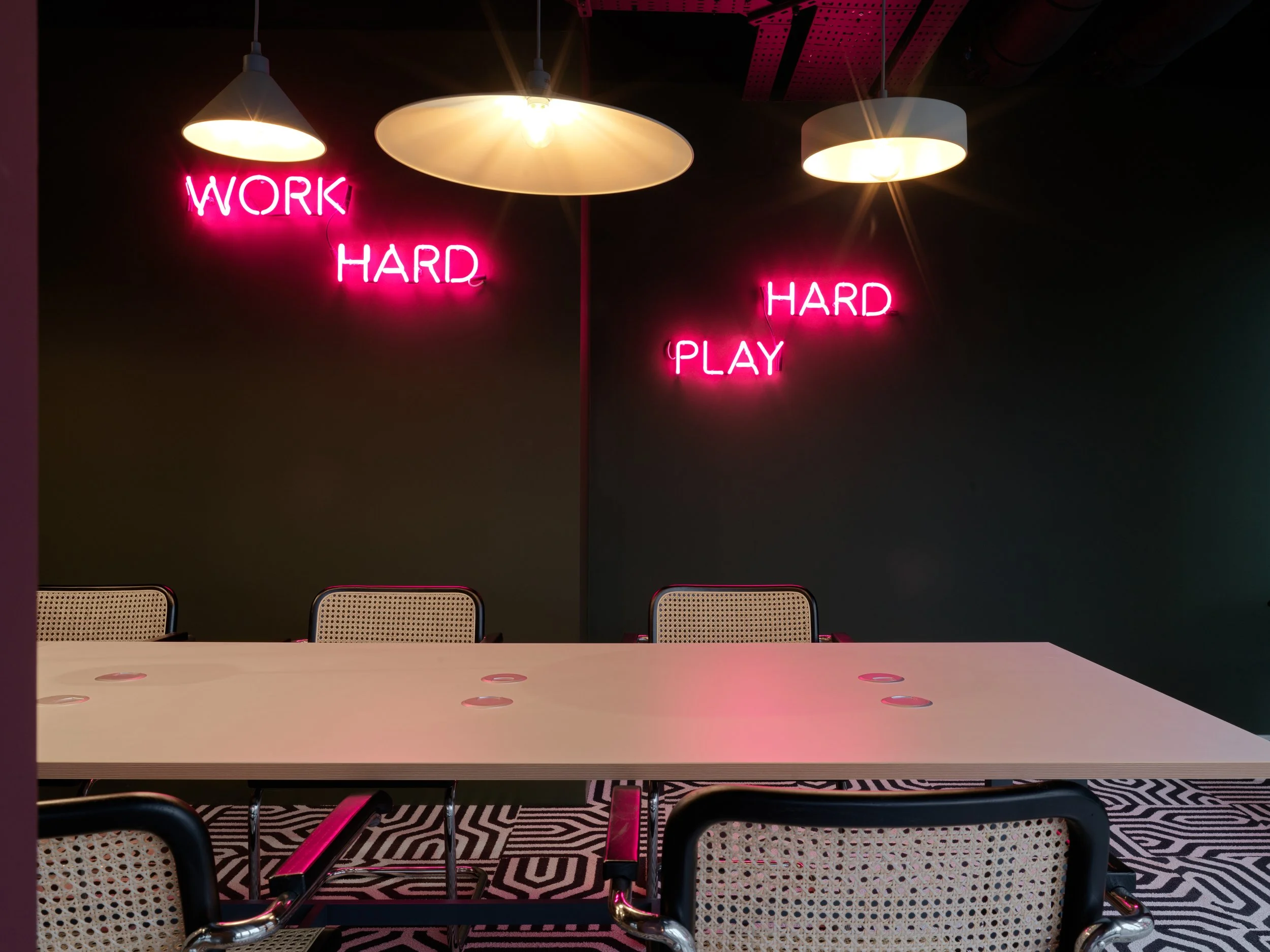 co-working space with work hard play hard pink neon signs
