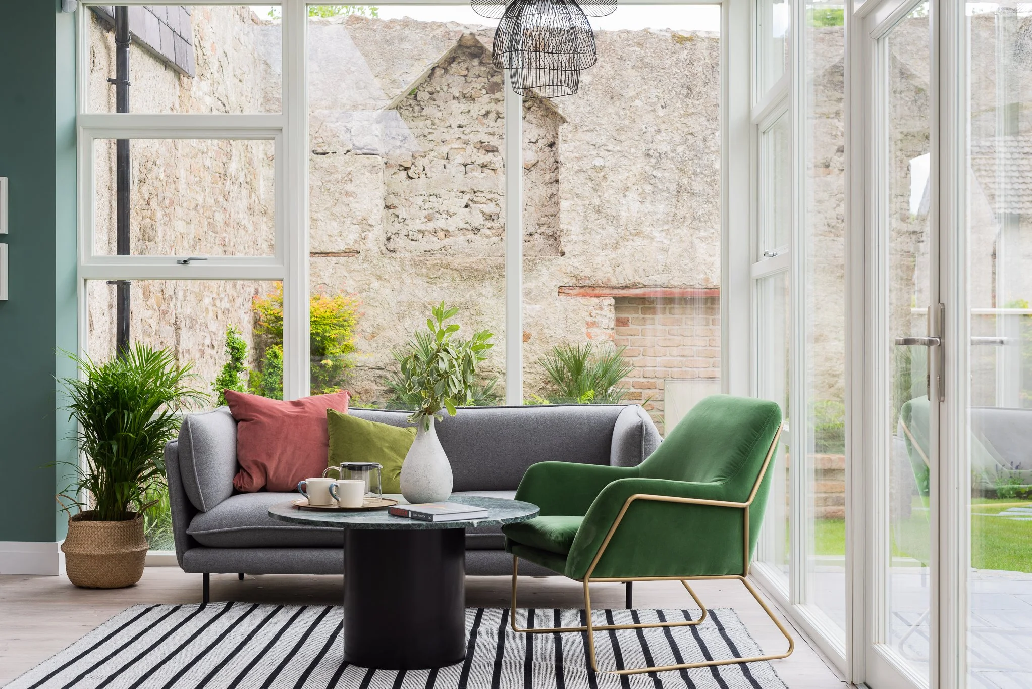 glazed living areas with grey sofa and green armchair
