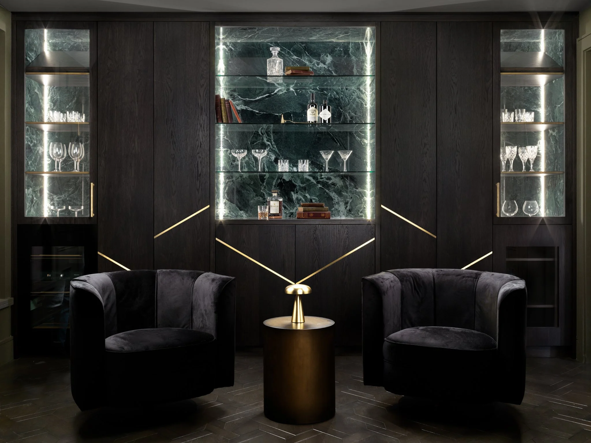 Black cabinet joinery with gold inlays & black arm chairs