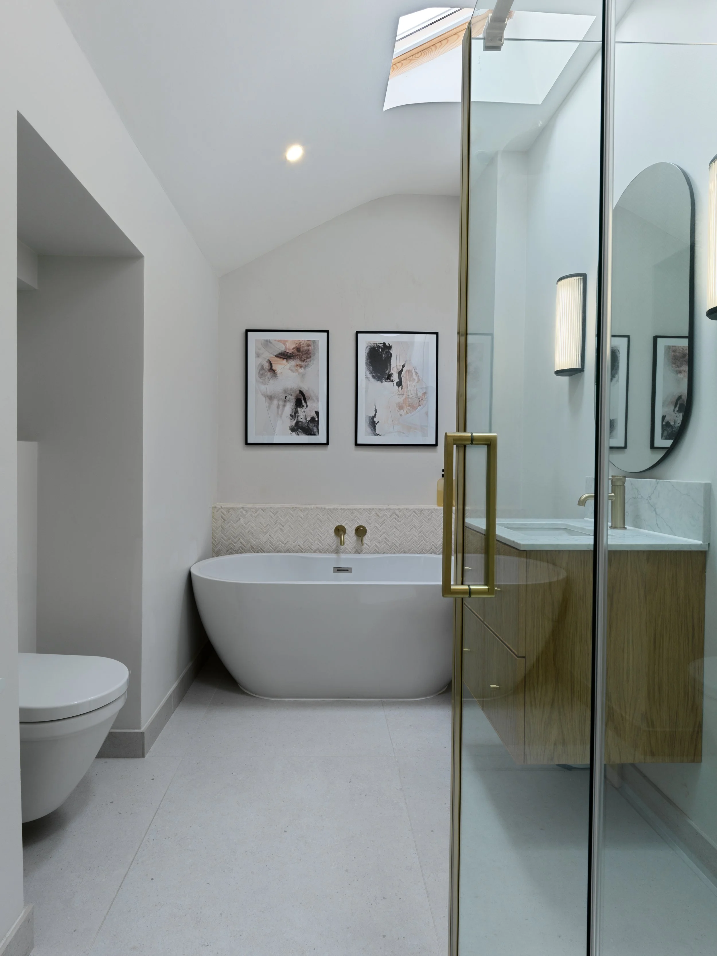 contemporary bathroom with white bath, oak sink unit and shower door