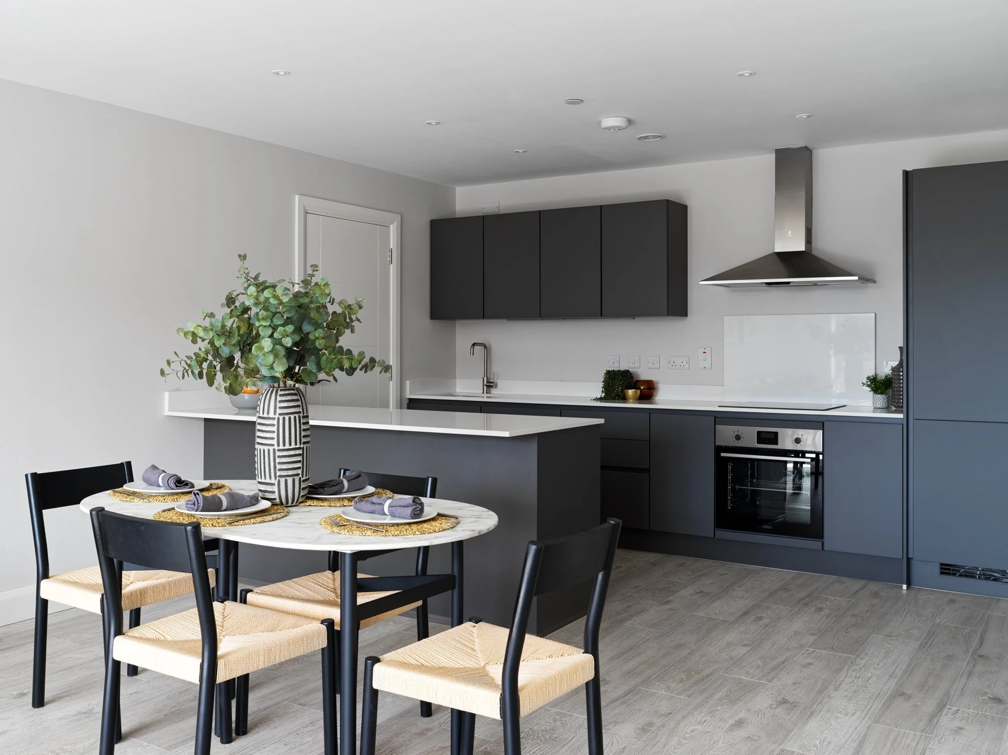open plan kitchen-living area with grey cabinetry