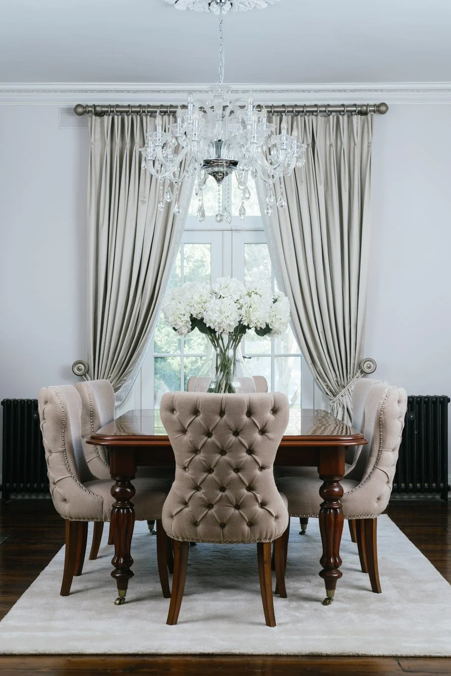 dining area with large dining chairs under chandelier 