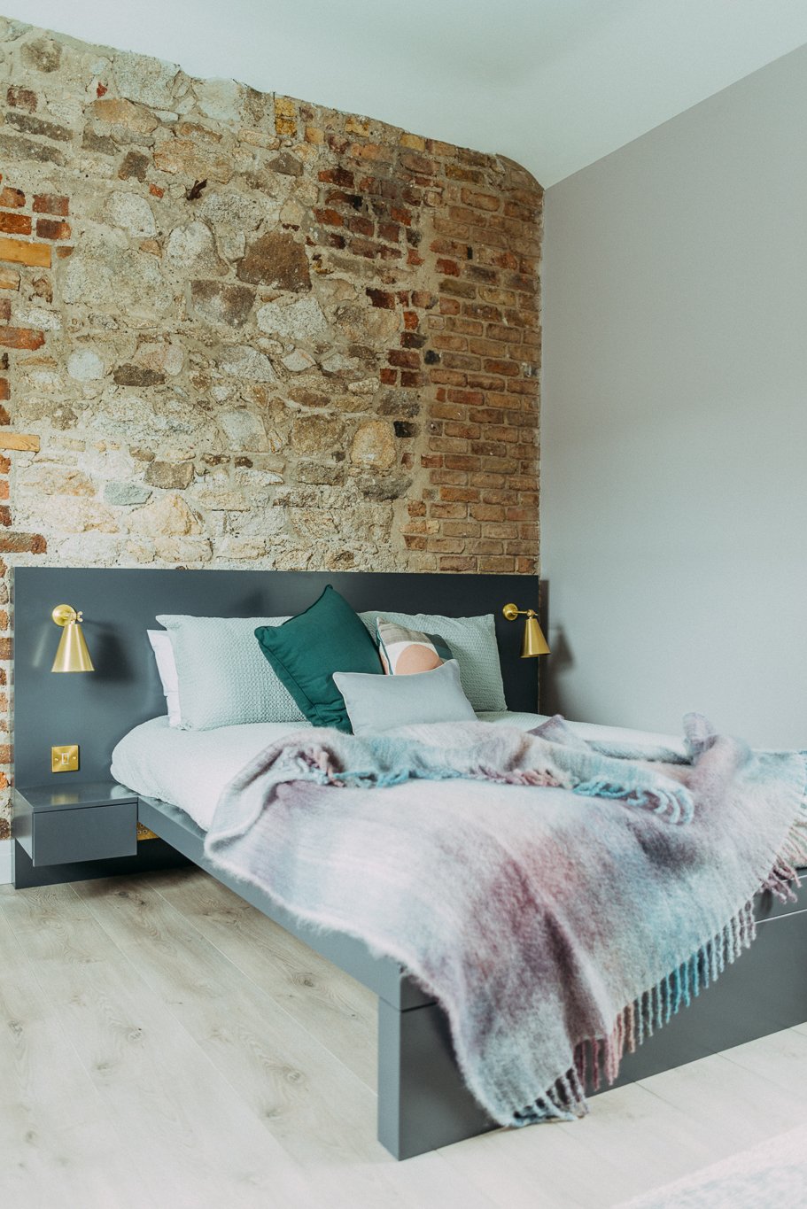 double bed against old brick wall
