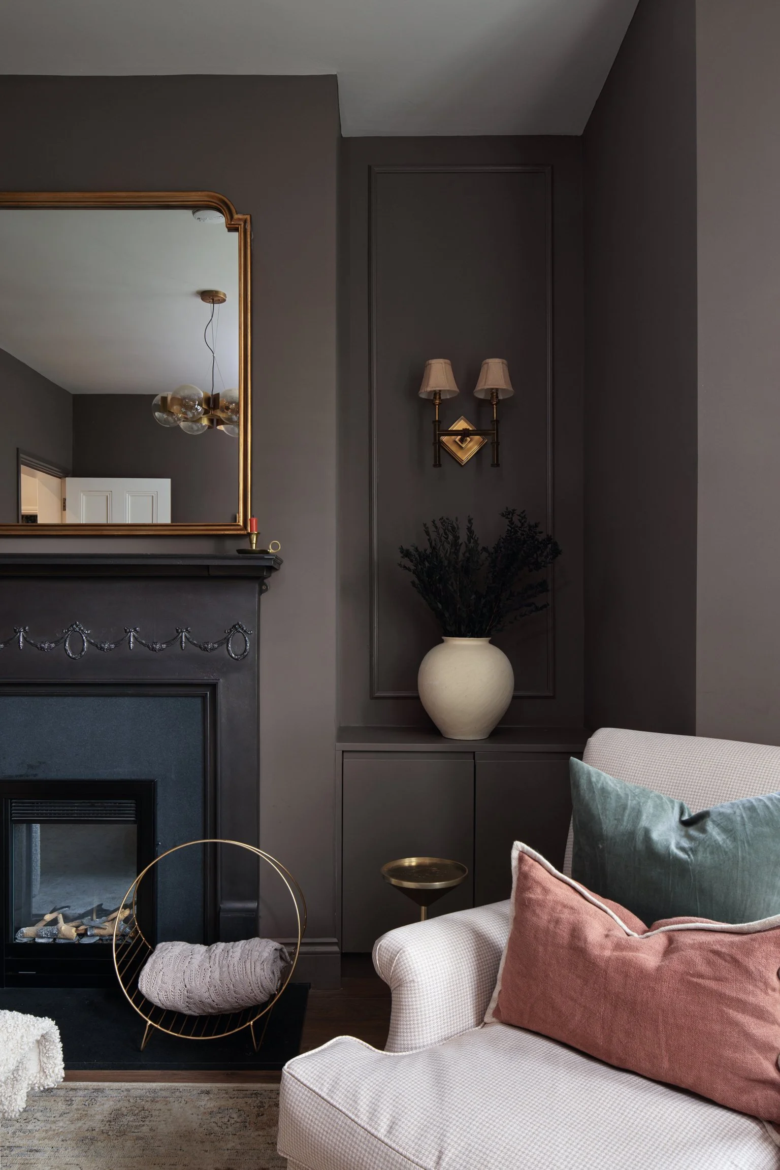 dark brown living room fireplace with gold wall lamps