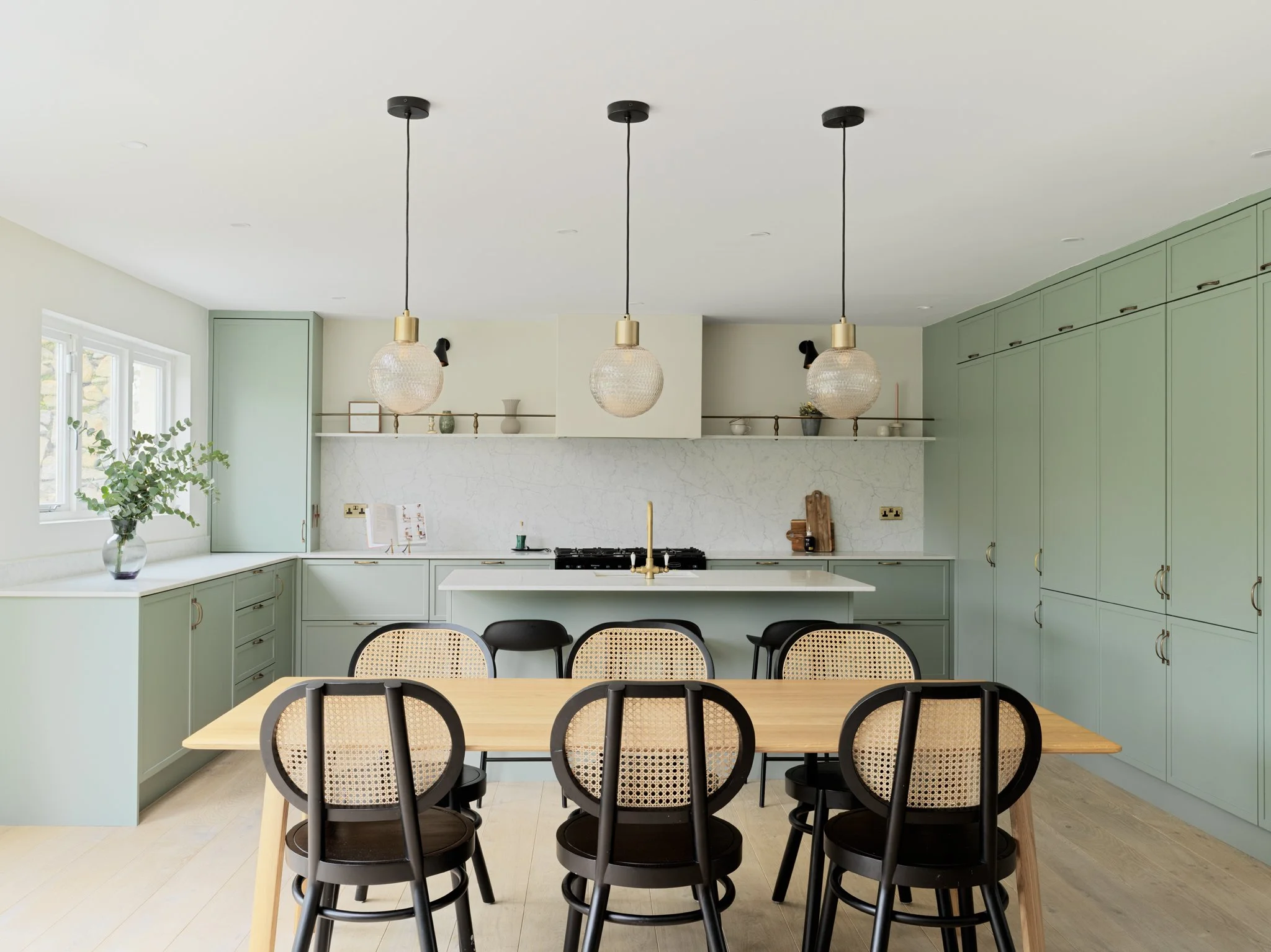 sage green open plan kitchen/dining with oak dining table & 3 pendant lights