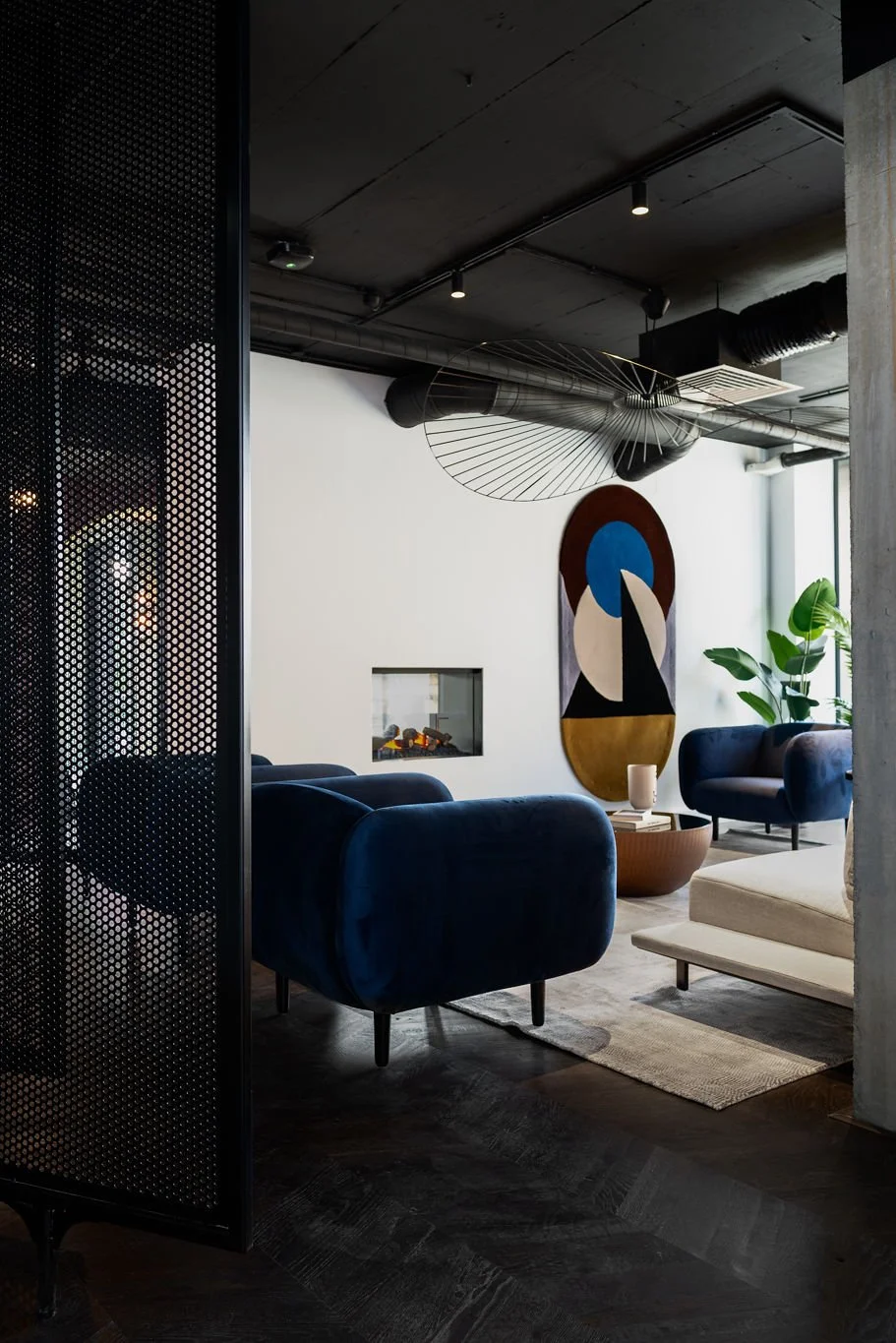 co-living relaxation space with large blue armchairs & wall art