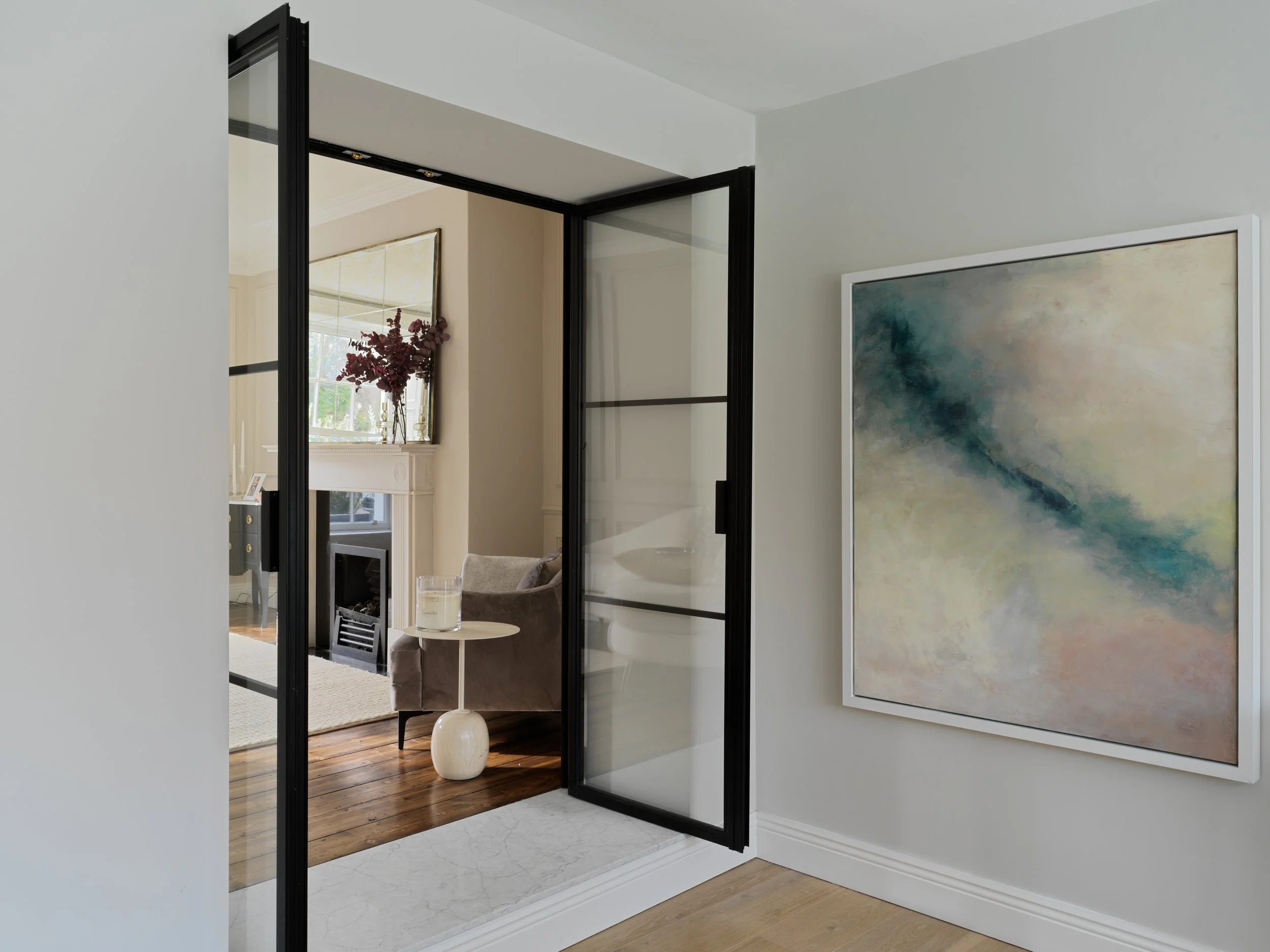 black and glazed interior doors into living area with large artwork