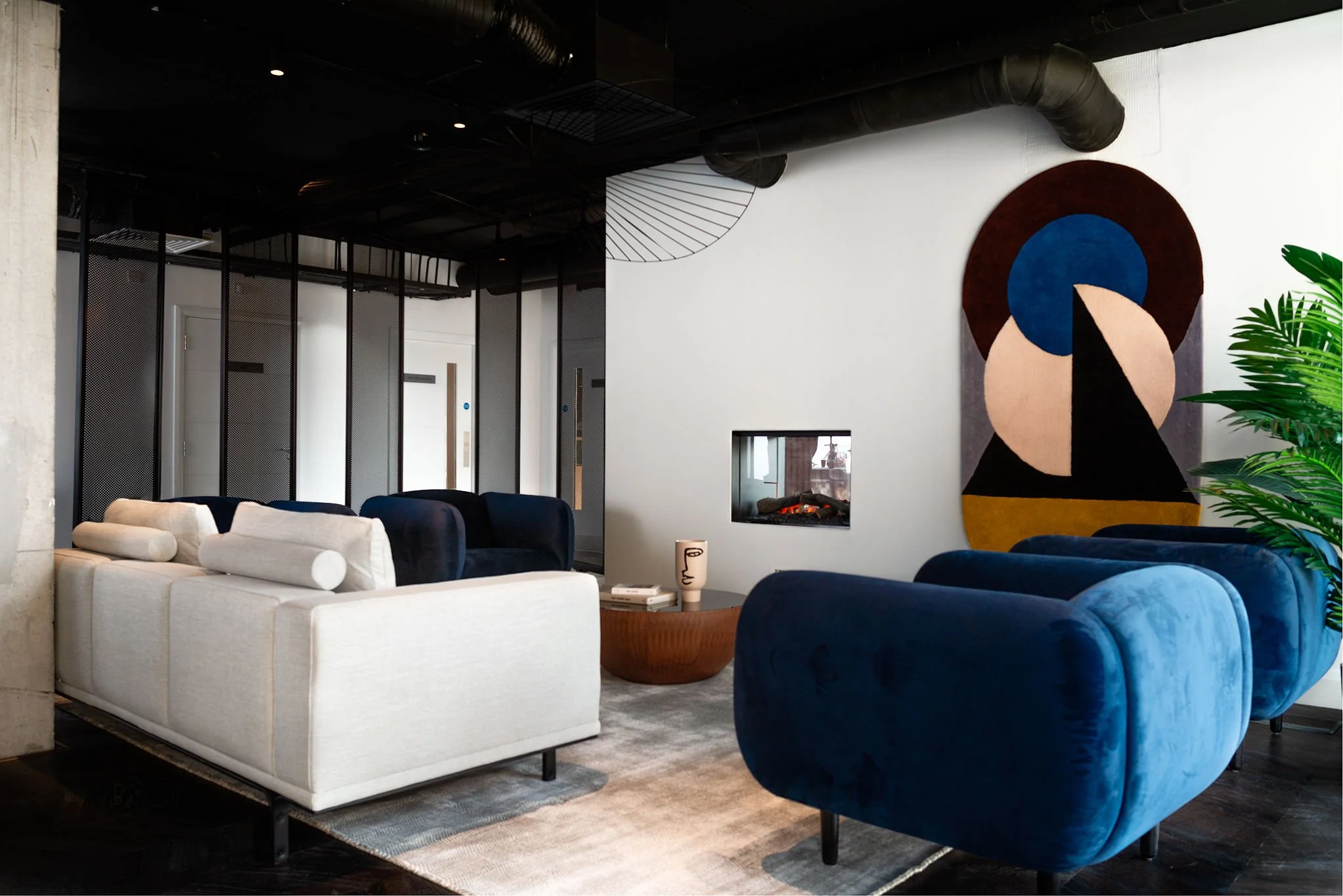 co-living relaxation space with large blue armchairs & wall art