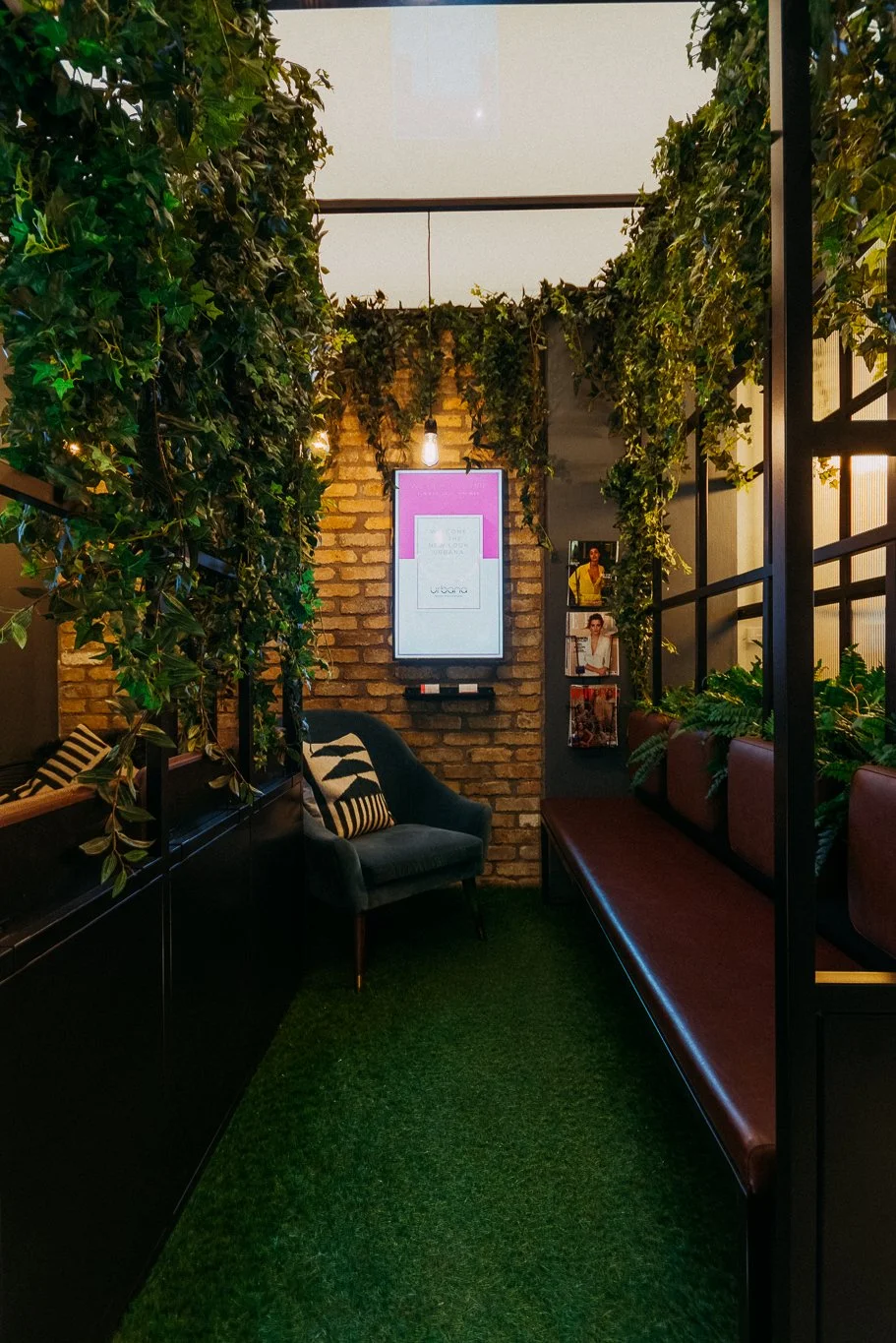 rustic and industrial waiting area with greenery and LED notification screen
