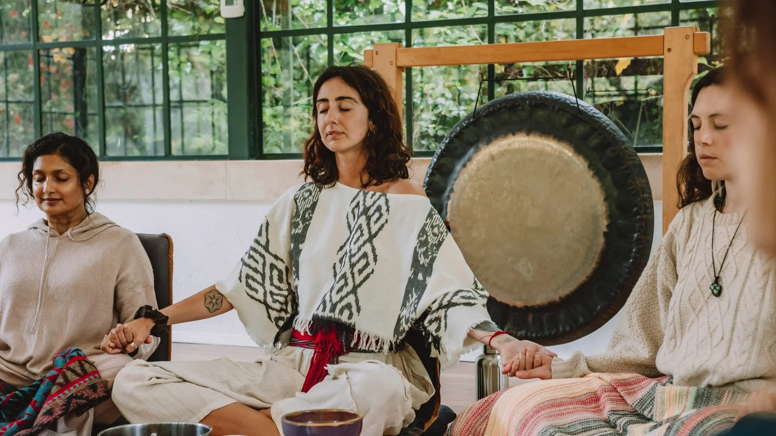 Women meditating with gong in channelling and spiritual communication session in greenhouse studio Ericeira Portugal