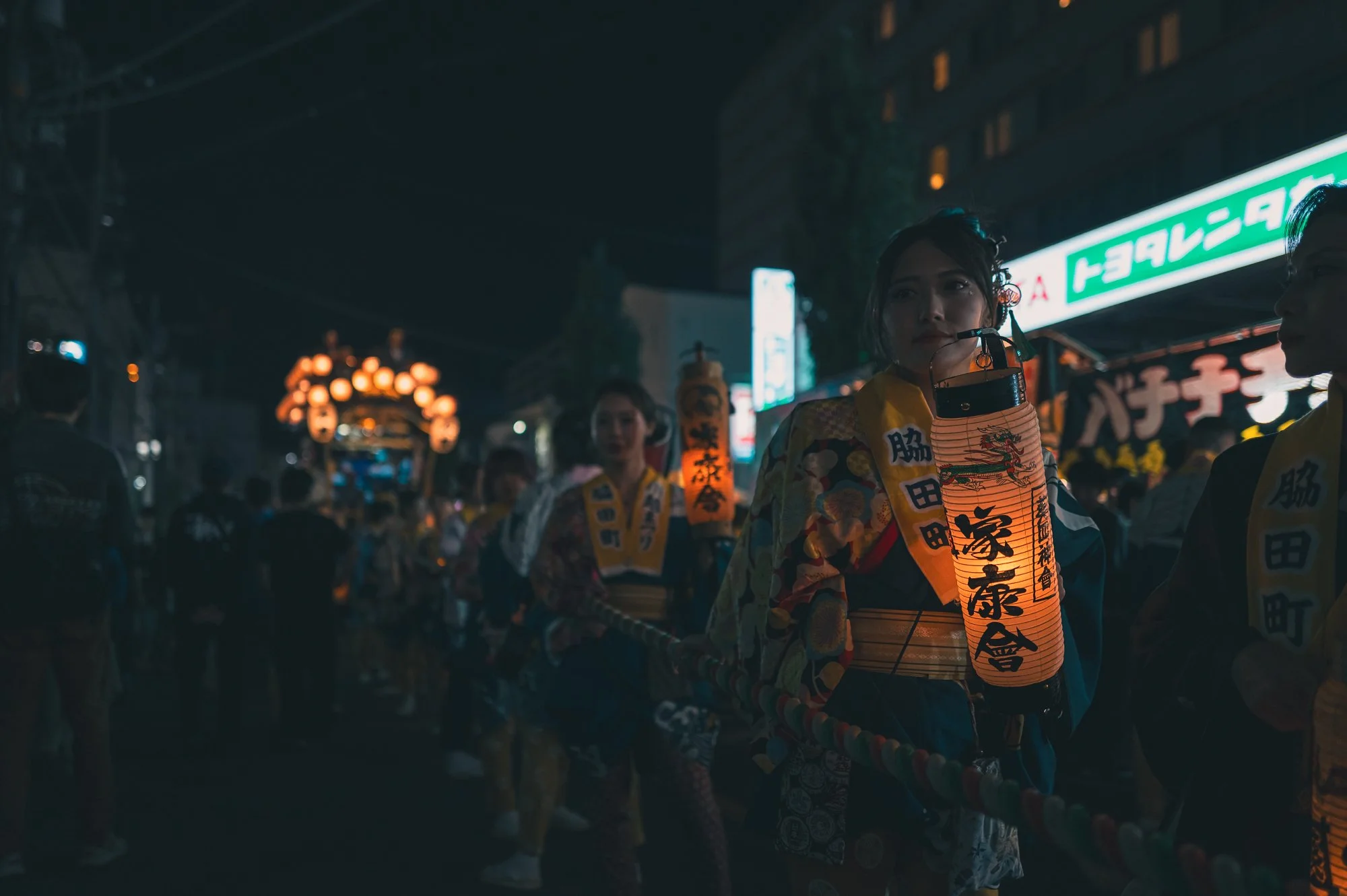Print AD-0035. A lantern bearer beside the procession after dark.