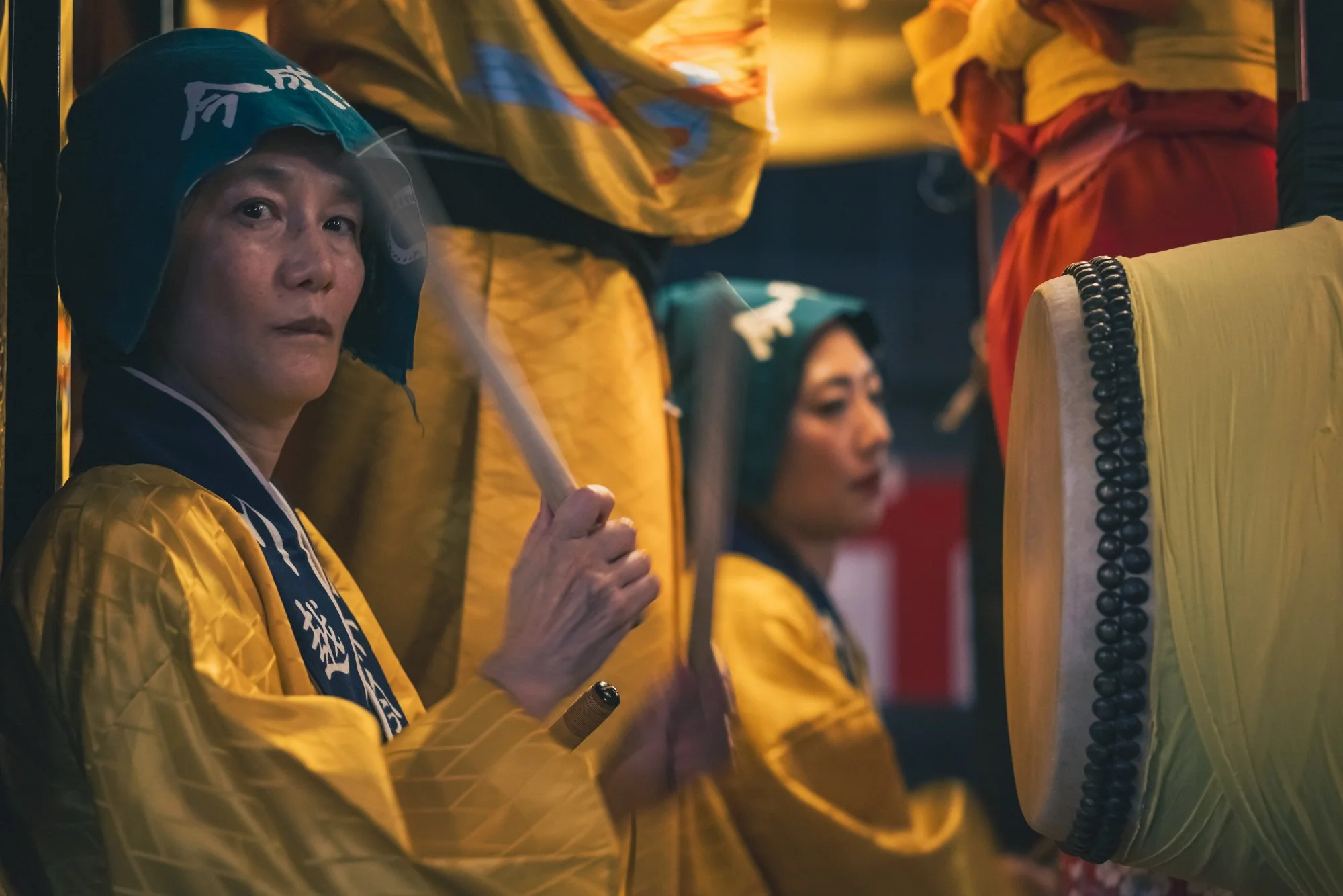 Print AD-0033. A drummer in yellow robes beside a drum.