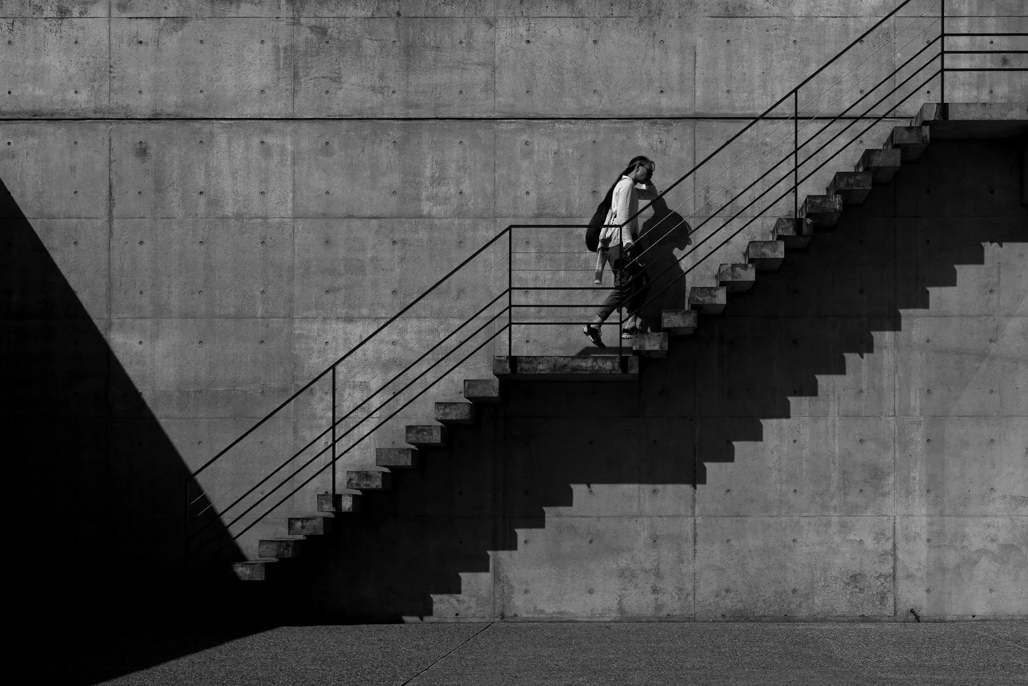 Print AD-0016. A person climbing a diagonal concrete staircase.