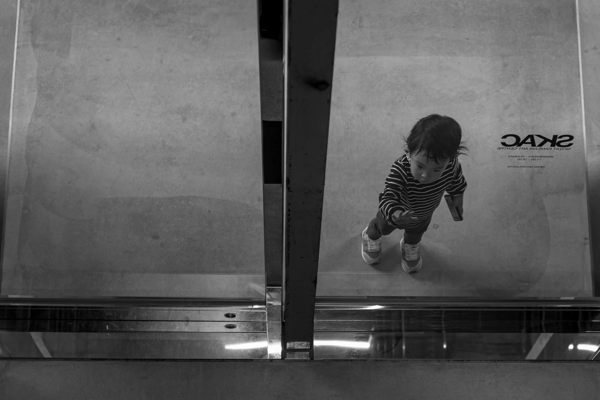 Print AD-0004. A child looking through glass.