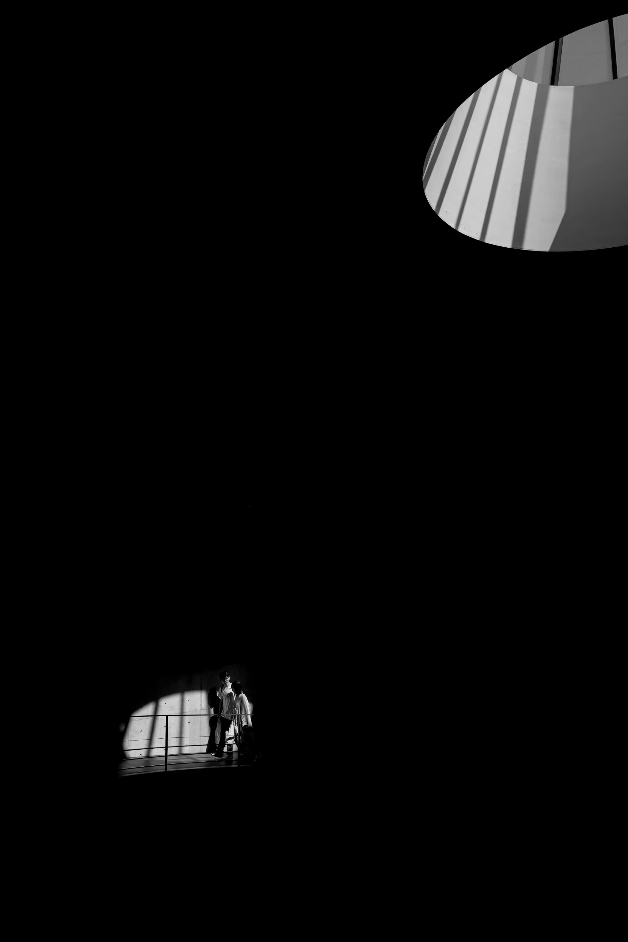 Print AD-0015. Figures in a small pool of light beneath an oval opening.