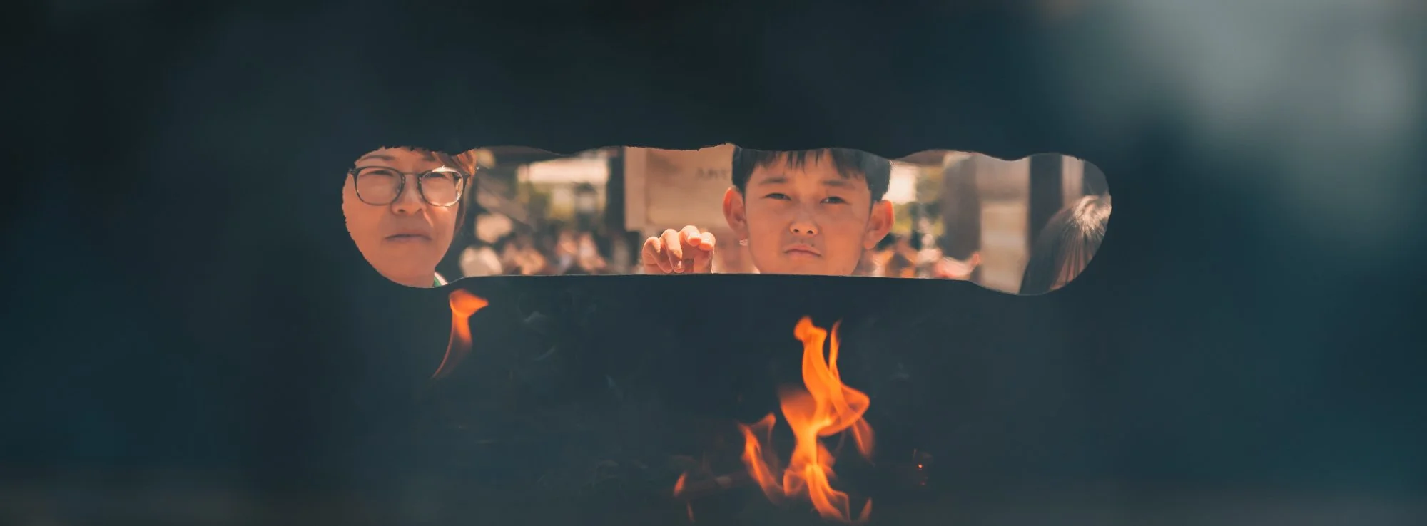 Print AD-0006. Faces and flame glimpsed through a narrow horizontal opening.