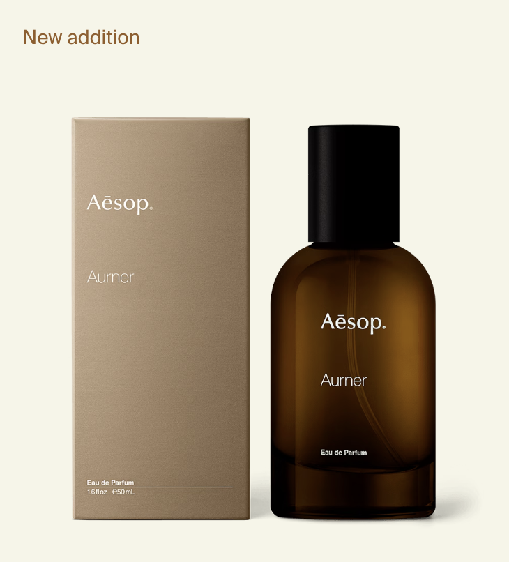 Aesop Aurner Eau de Parfum in a brown glass bottle with black cap, displayed alongside its beige packaging box.