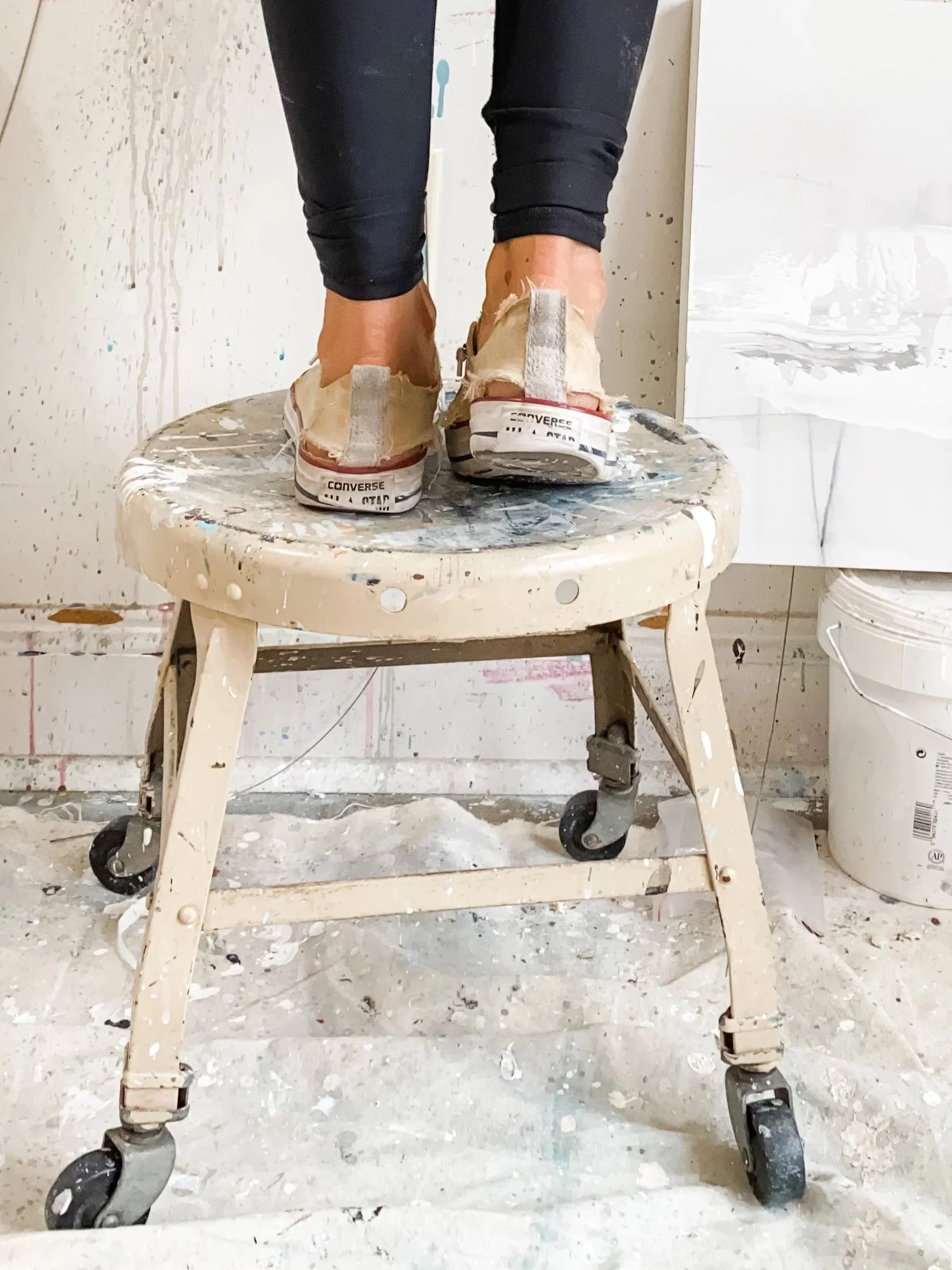 Chris Brandell painting in her favorite chucks on a studio stool in VA studio