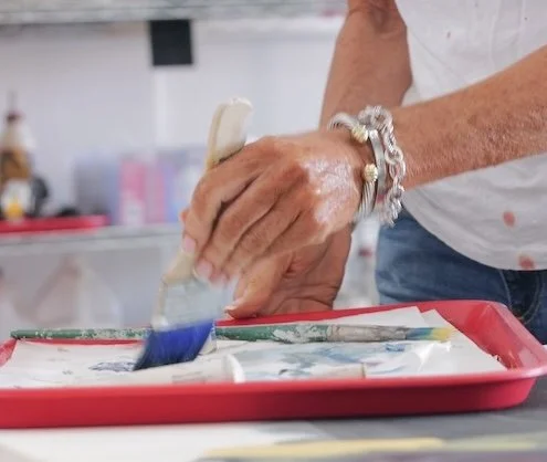 Chris Brandell's hand in action with a paint brush close up in the Marco Island studio