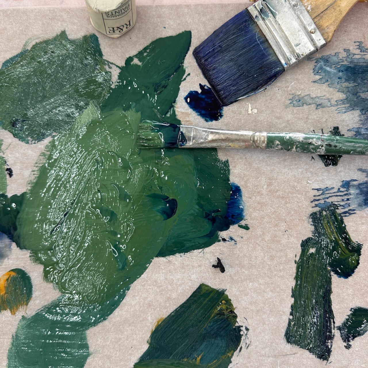 beautiful green and blue paint with brushes in the studio of Chris Brandell