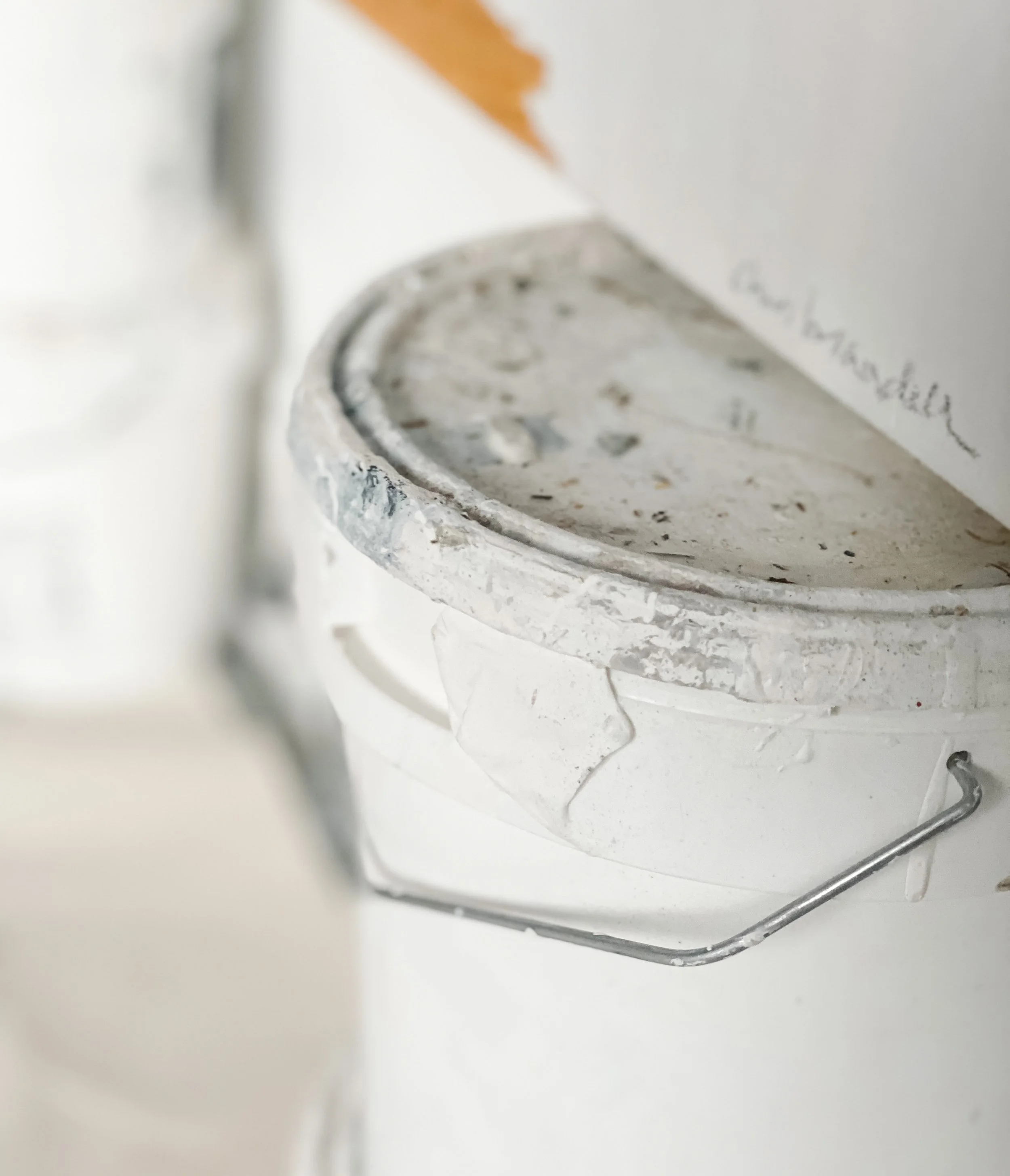 A close up of a Chris Brandell signed painting resting on a paint can