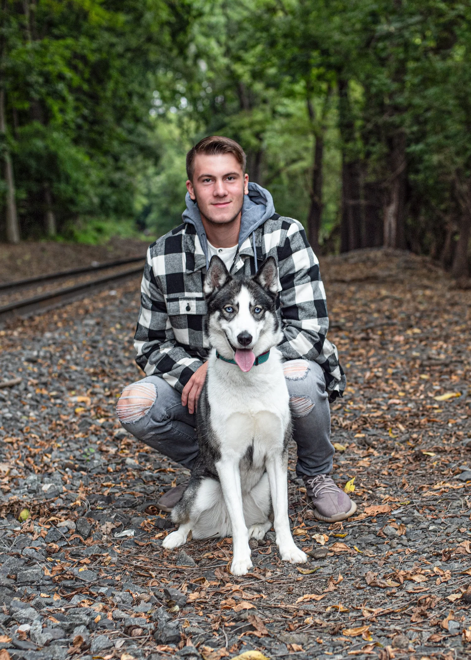 High school senior guy kneeling with his husky