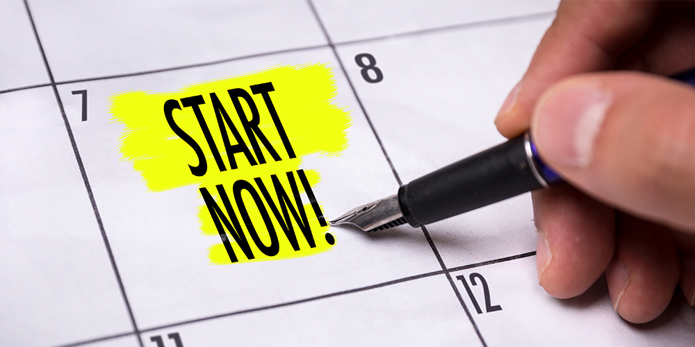 "Start now" is printed on a calendar and highlighted in yellow. A hand holding a pen is pointing to it.