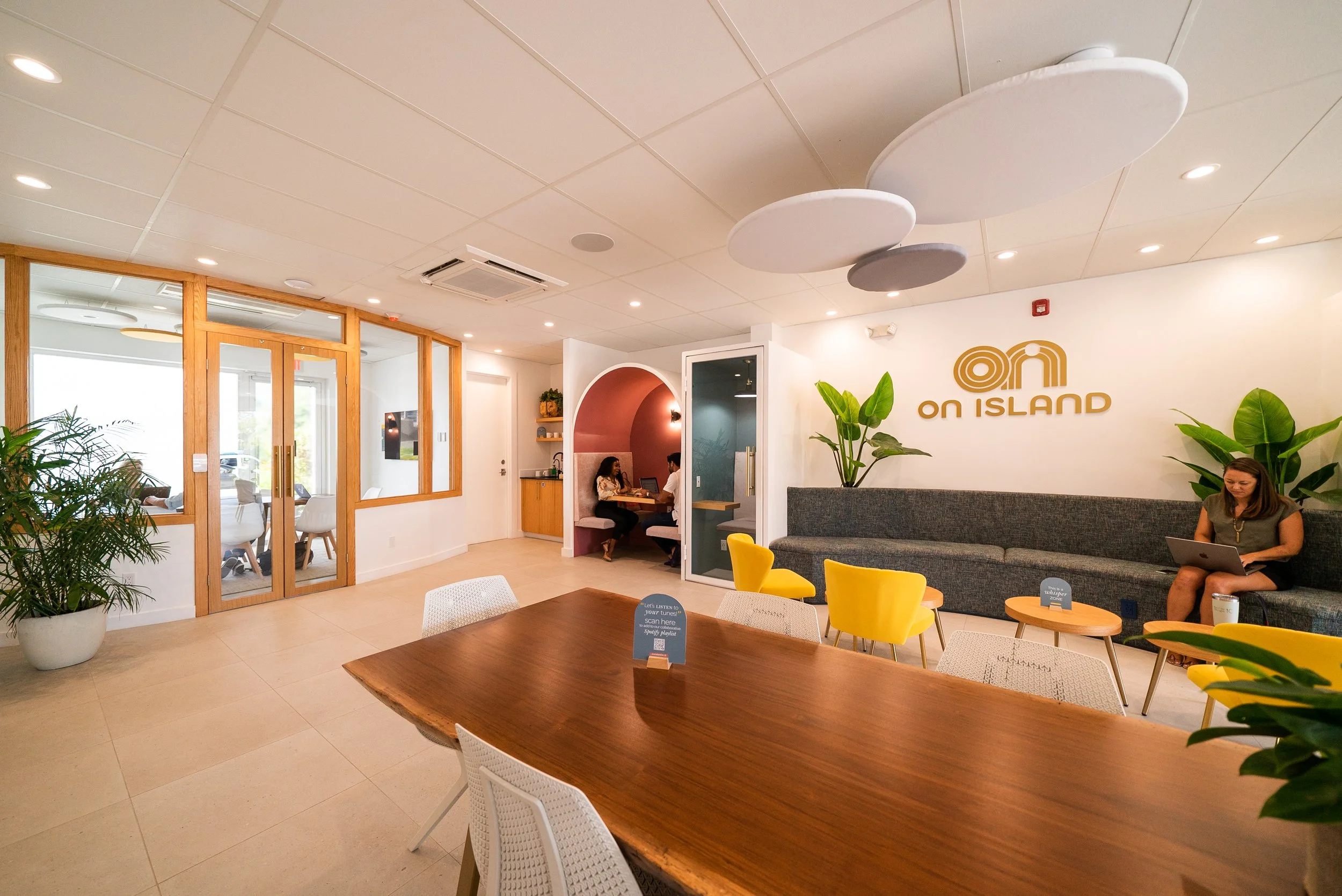 Bright meeting space at On Island coworking in Grace Bay, Providenciales, with a long wooden table for AGMs and board meetings