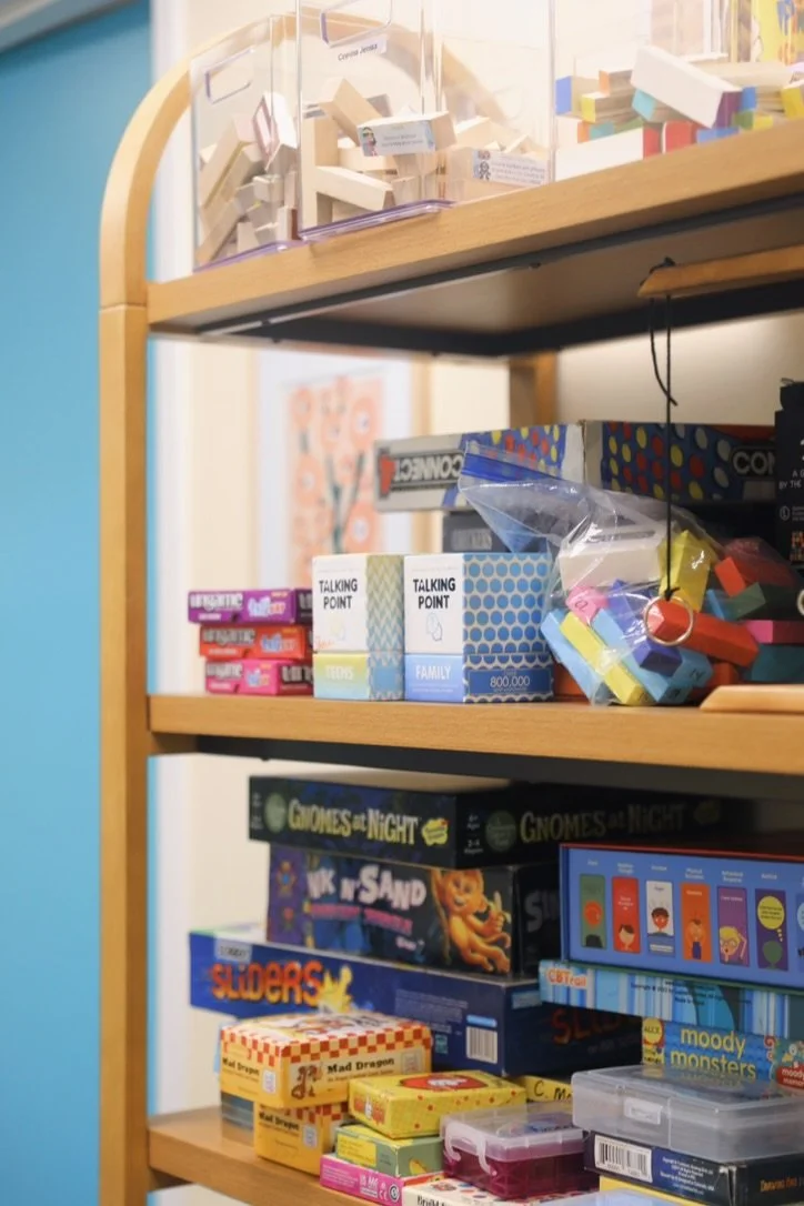 Bookshelf full of games used in child and teen therapy