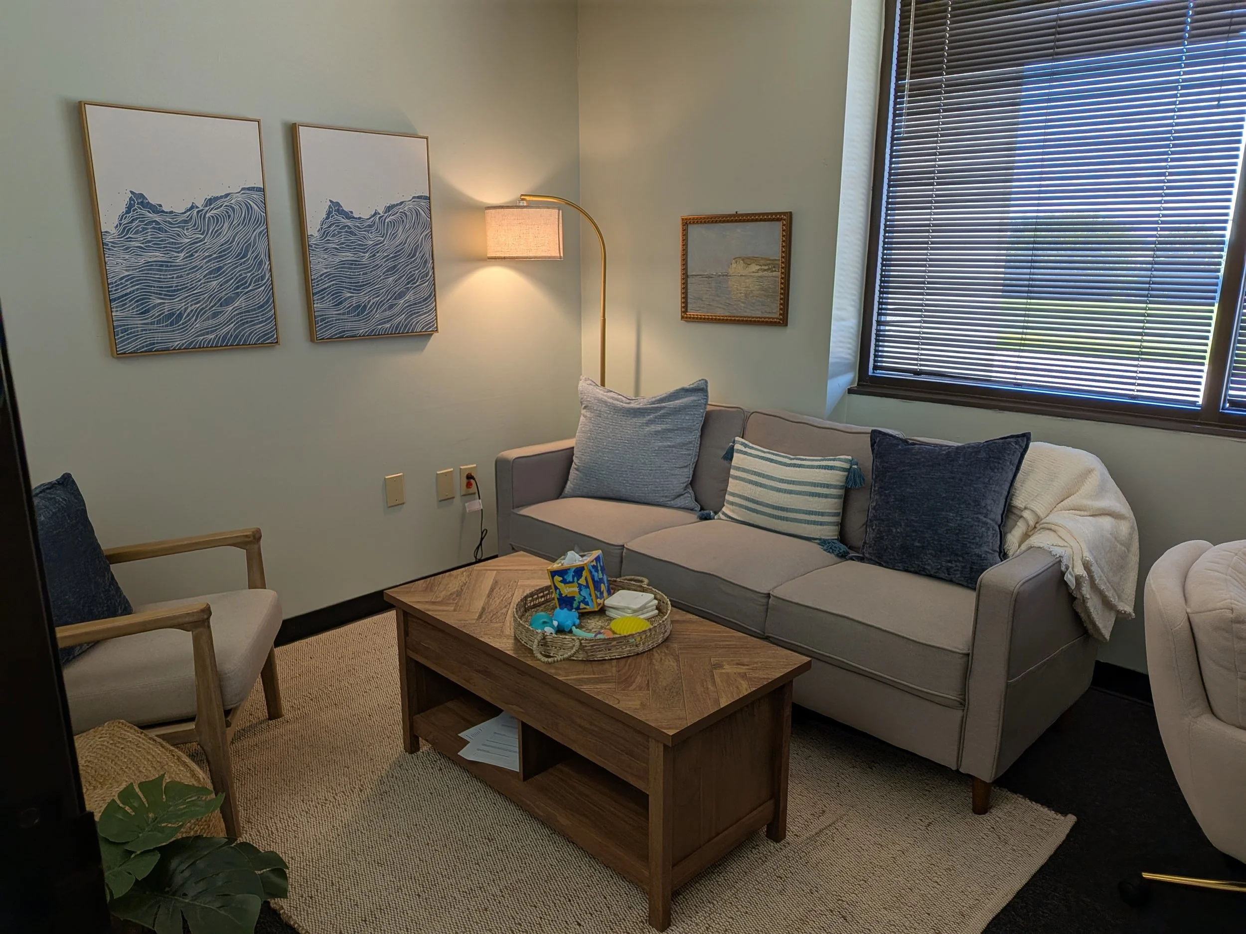 Counseling room with beige couch and arm chair and soft wall colors