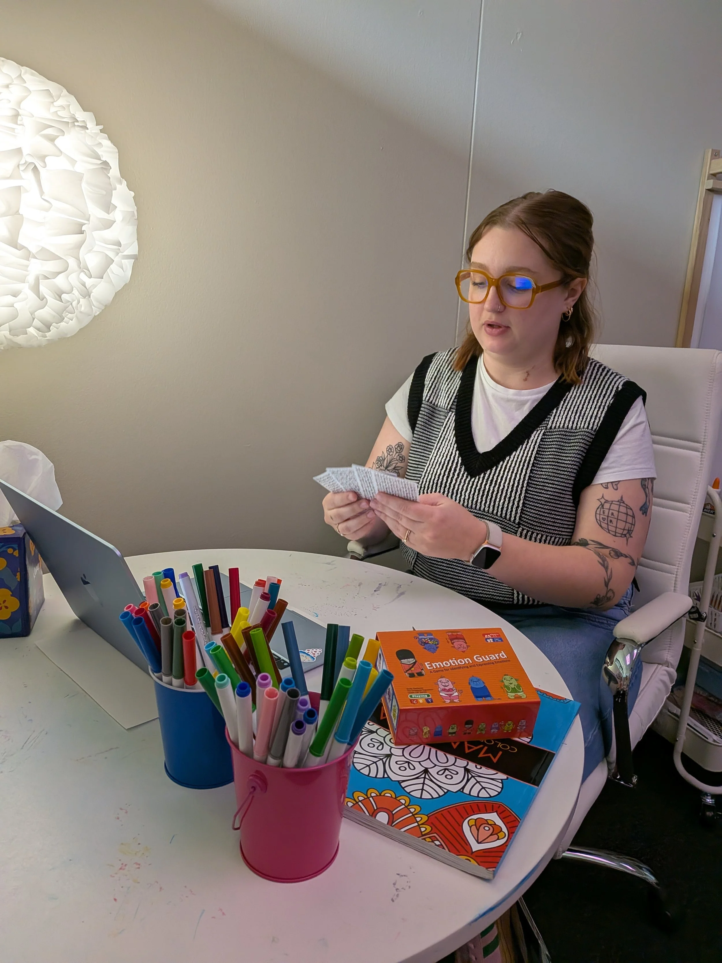 Therapist in an online therapy session using creative techniques and playing cards