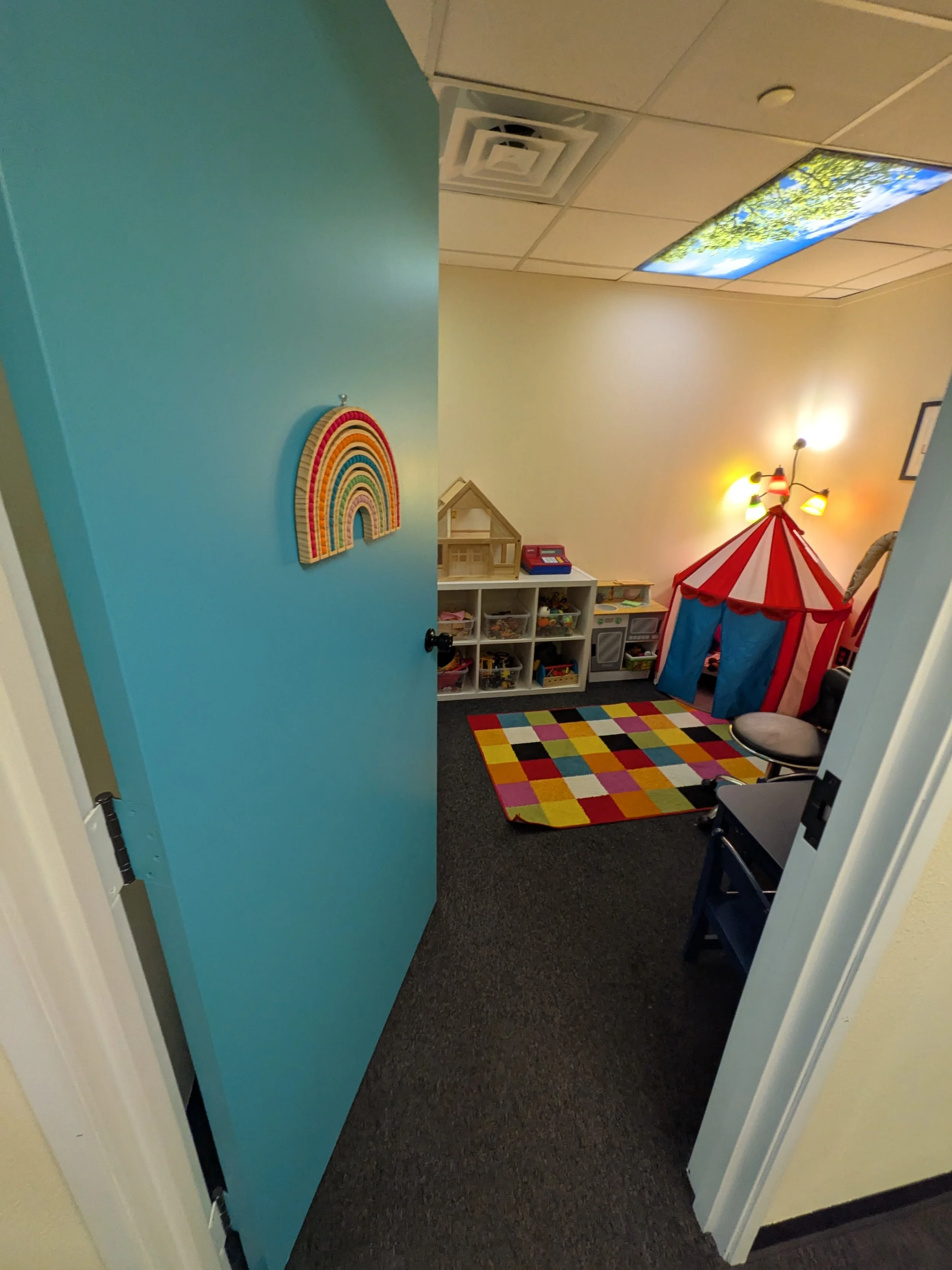 Play room with teal door with rainbow. 