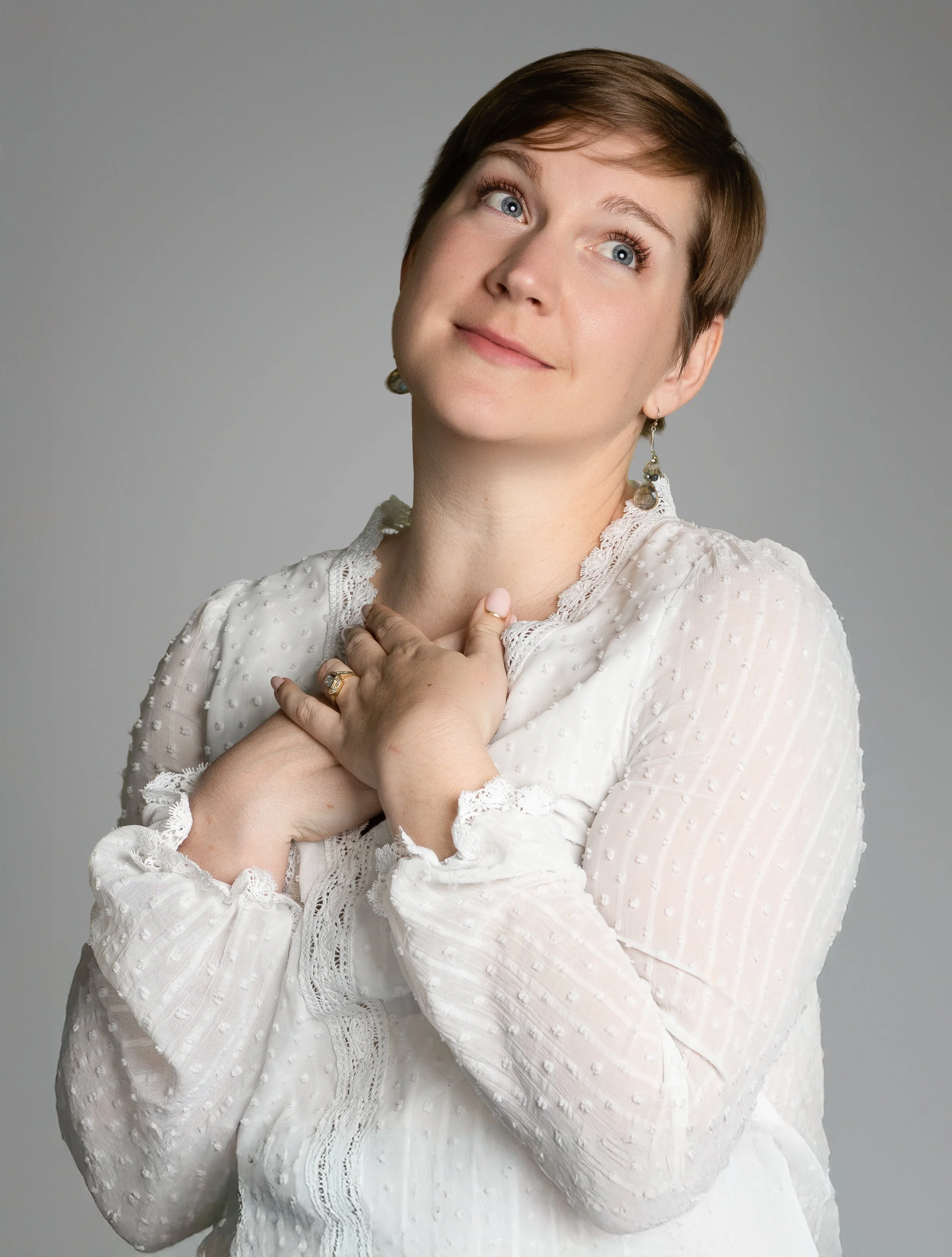 headshot of a woman wearing a white blouse looking to the sky