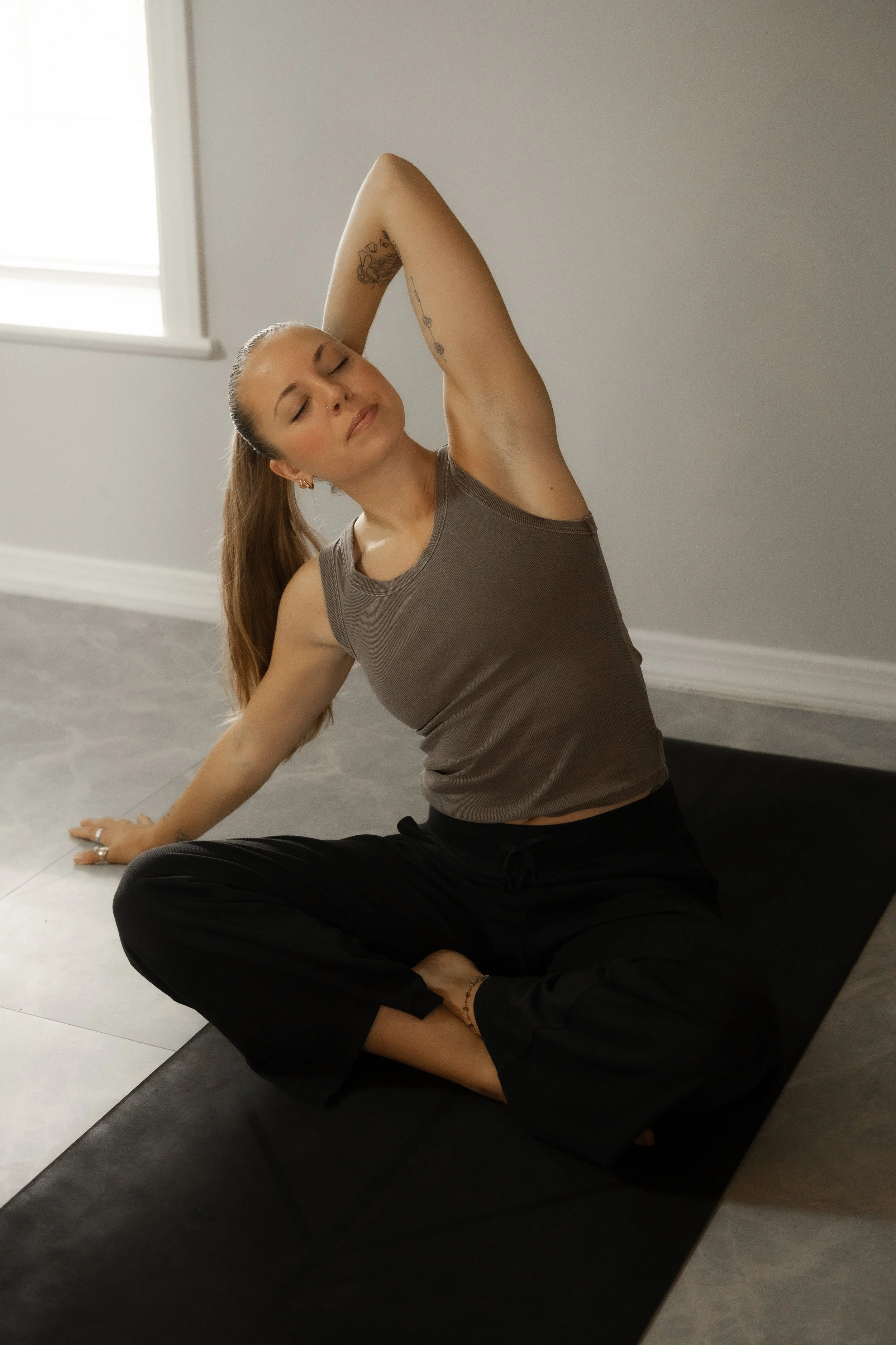 Carly Newberg, yoga teacher, stretching on her yoga mat.