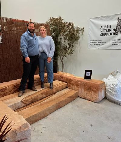 A photo of a man and a woman posing on a set of sandstone steps
