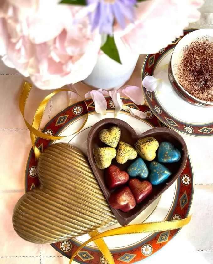 heart shape chocolates in a gold heart shape bowl