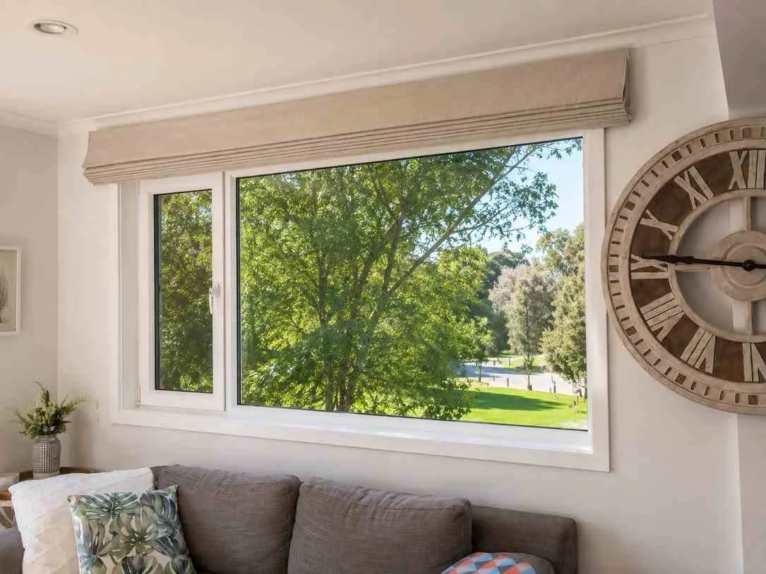 Large window looking out to outdoors with a beige blind
