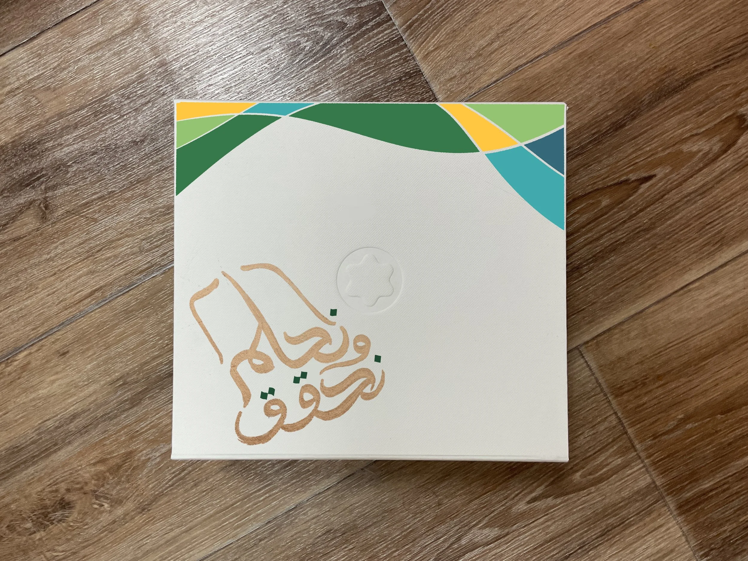 Close-up of a paper with a colorful geometric design on a wooden surface.