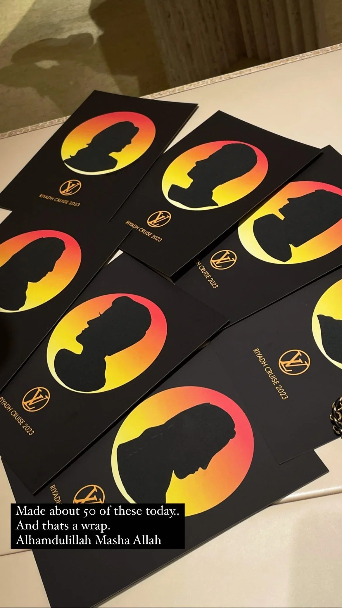 Several black cards with silhouette profiles of different people within a sunset-colored circle, lying on a table.