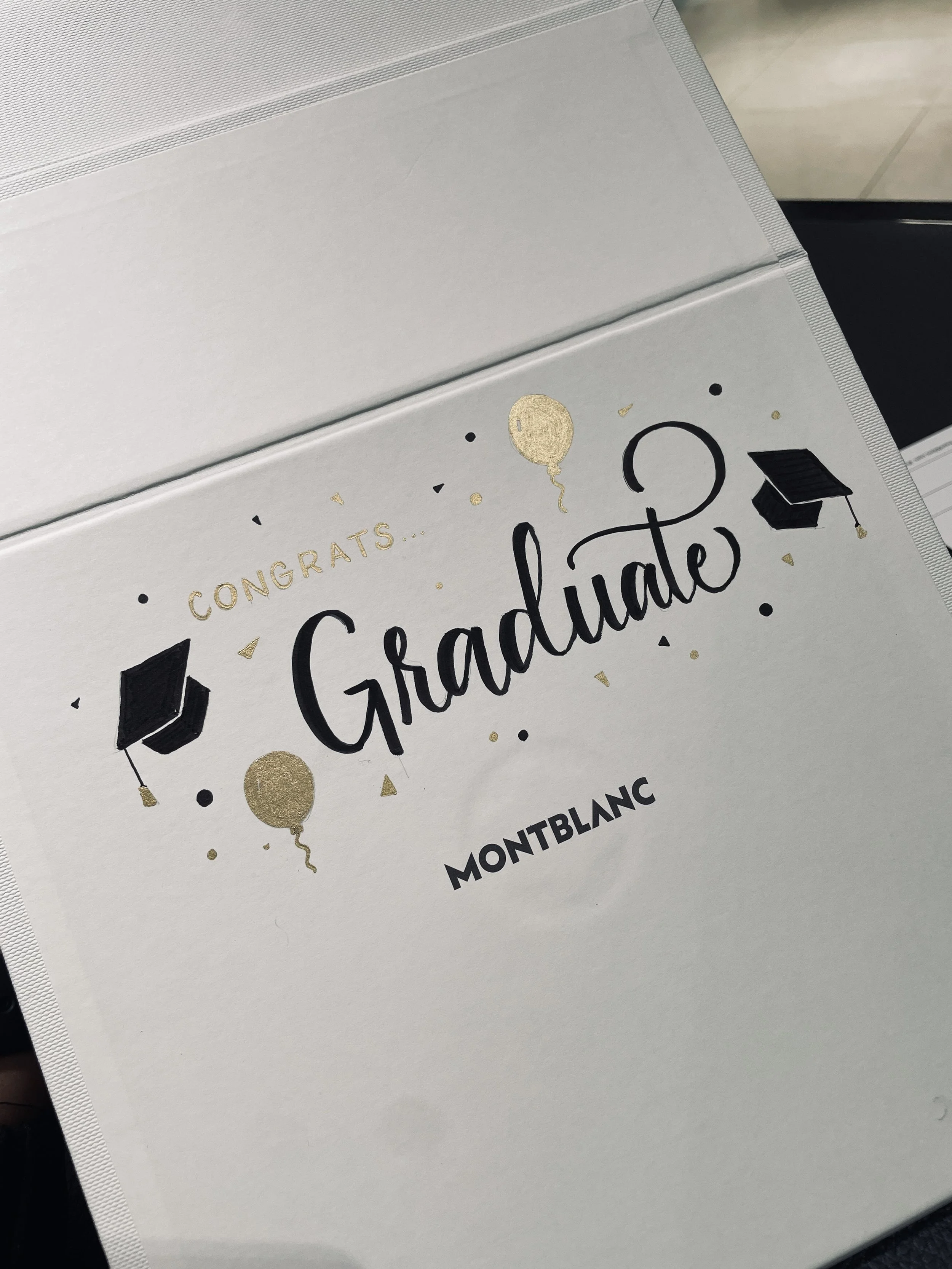 Graduation cap and gown on an invitation card congratulating graduates