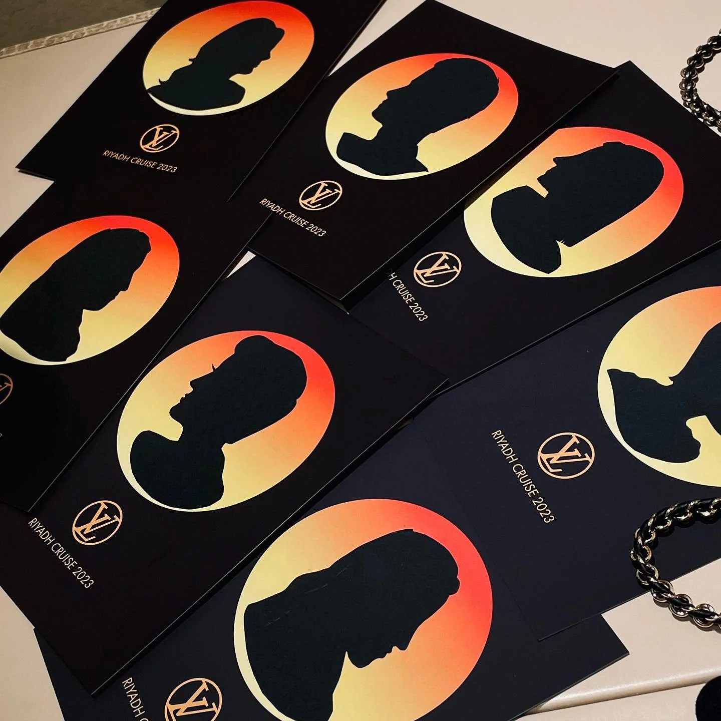 Several black flyers with silhouettes of a woman with a bun hairstyle inside a sunset-colored circle and the text "RIYADH CRUISE 2023" along with a logo at the bottom.