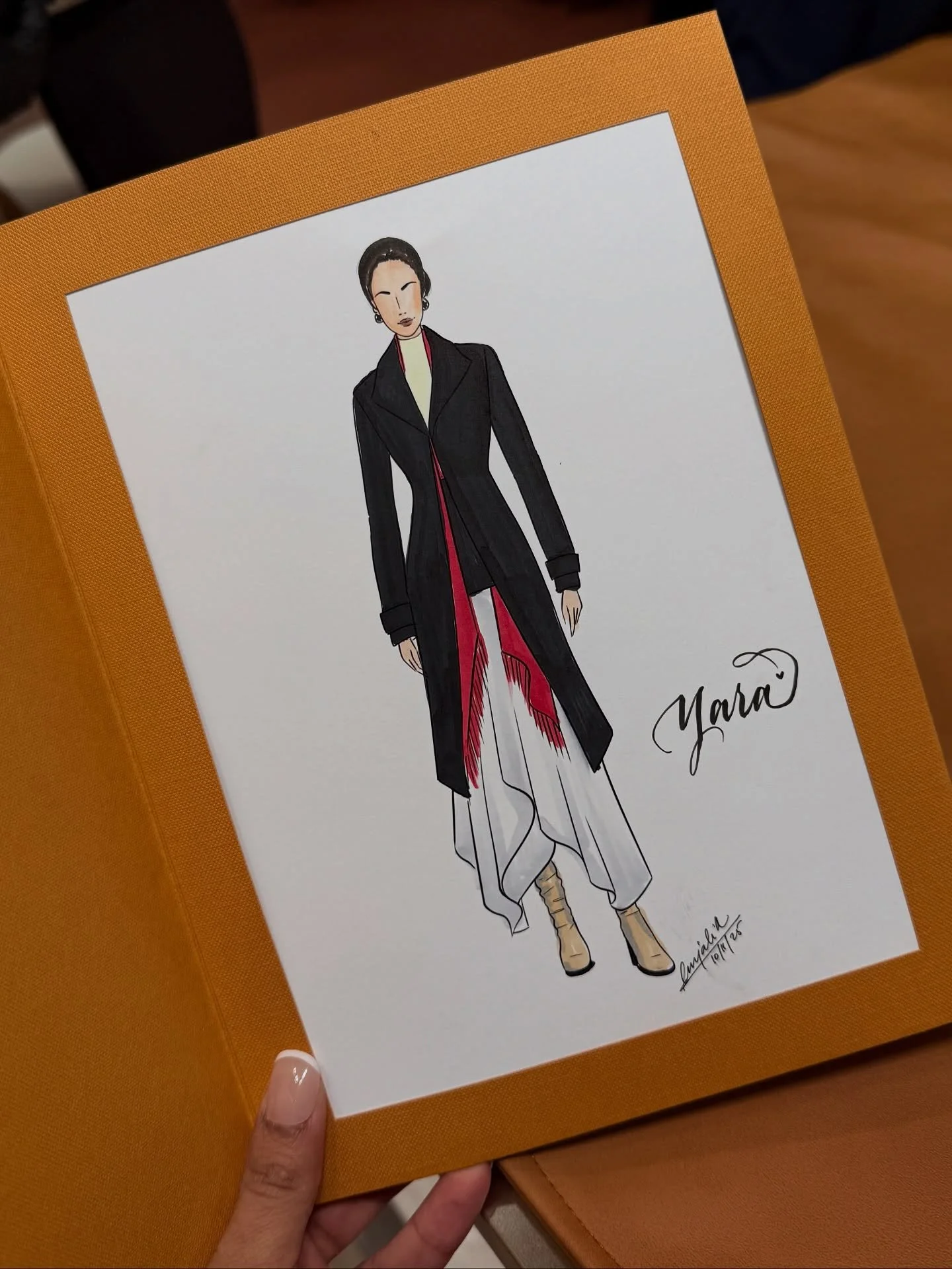 Fashion illustration of a woman wearing a long black coat with red and white inner clothing, beige high heels, earrings, and styled hair, accompanied by a signature and date.