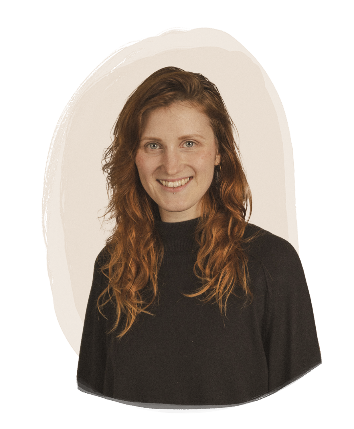 Porträt einer lächelnden Frau mit rotbraunen, lockigen Haaren, schwarzem Pullover und hellem Hintergrund.